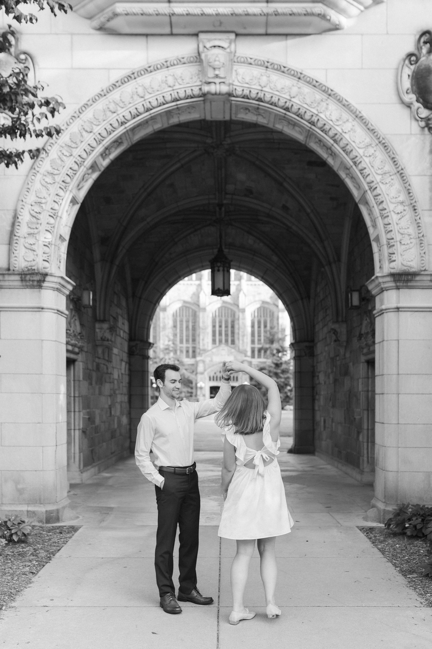 A series of four black and white photos showing a couple dancing under a stone archway.