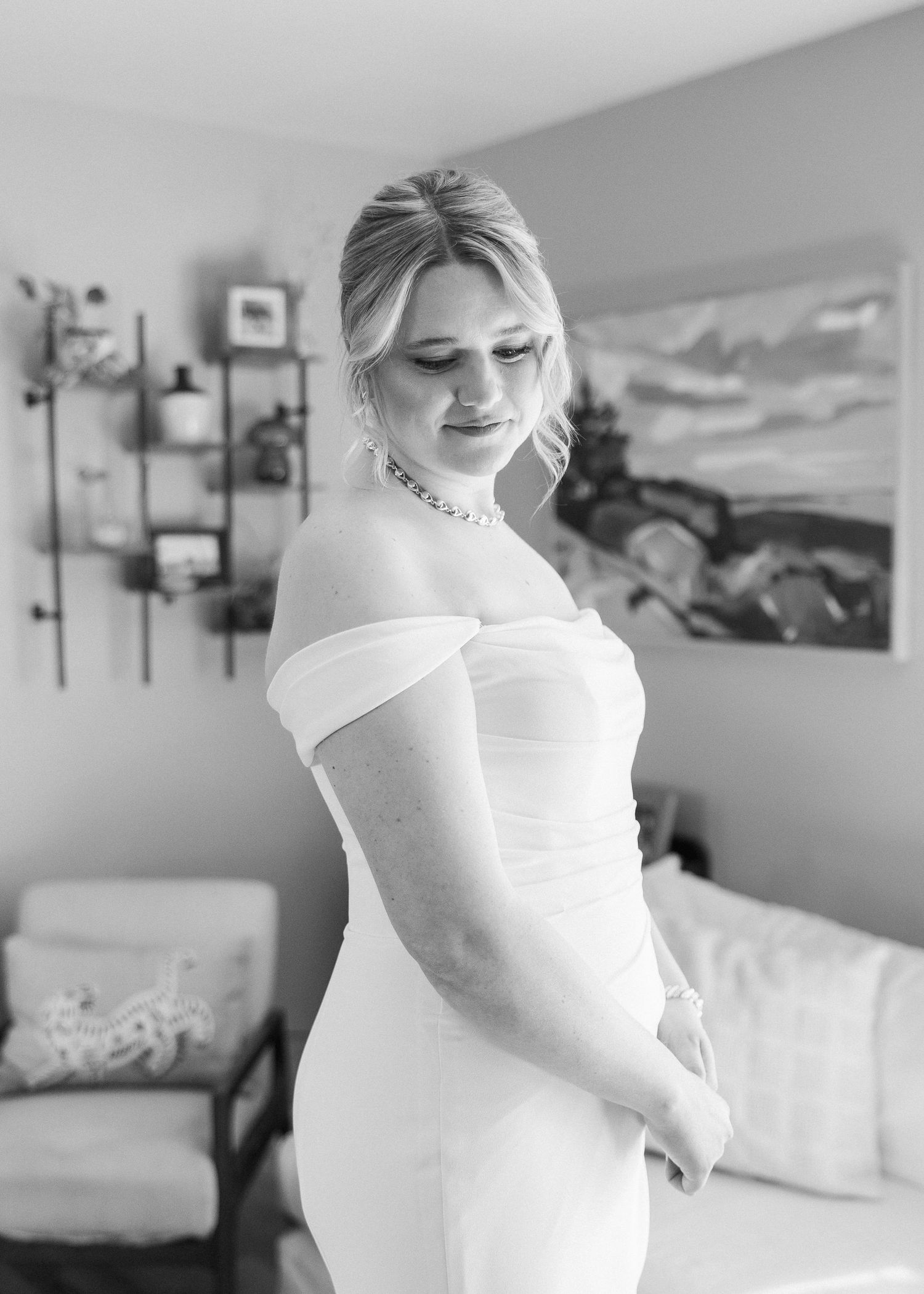 An elegant bridal portrait showcasing an off-shoulder wedding gown in a modern setting.