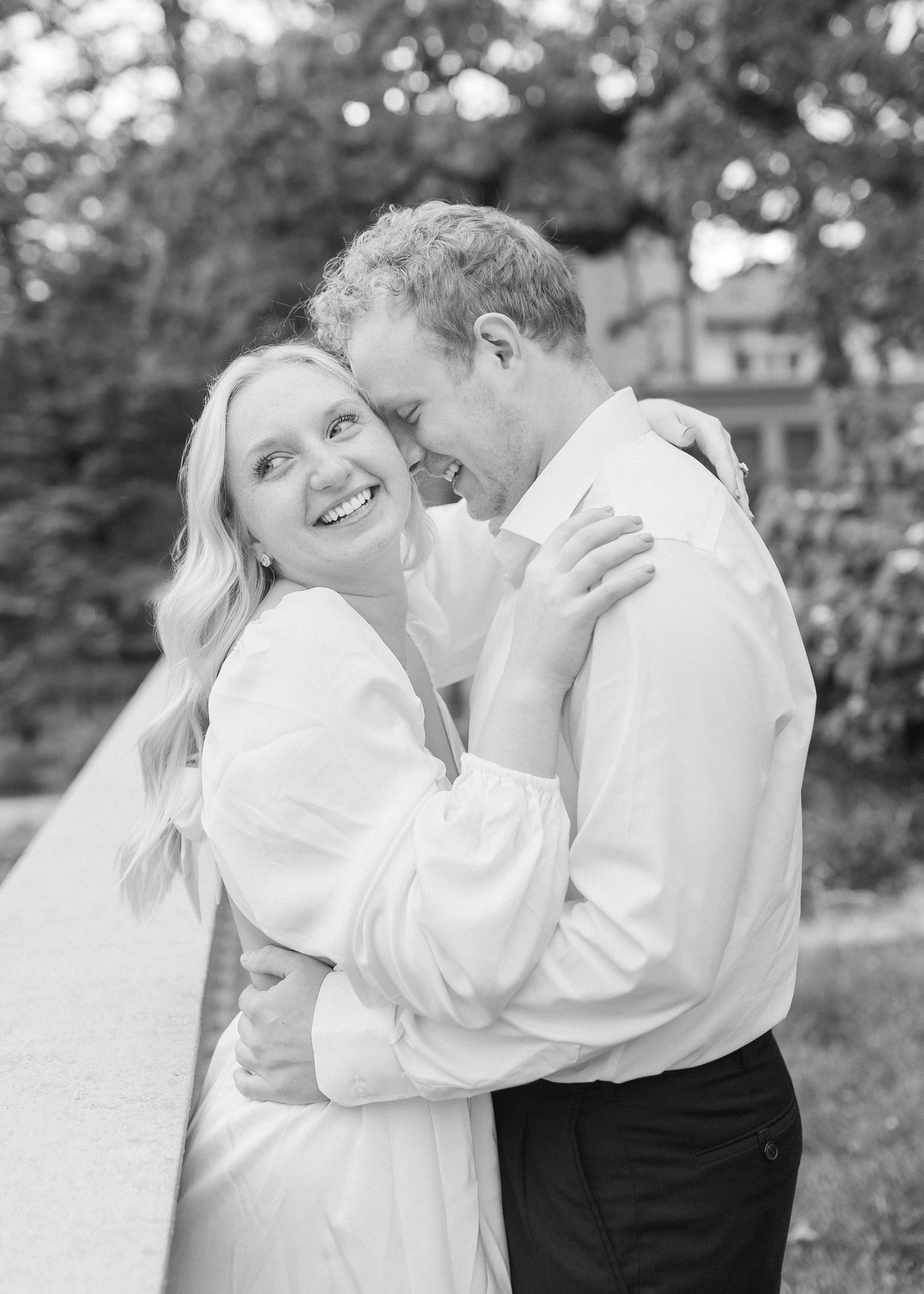 A couple in vintage-style clothing shares intimate moments in a black and white photo series set outdoors.