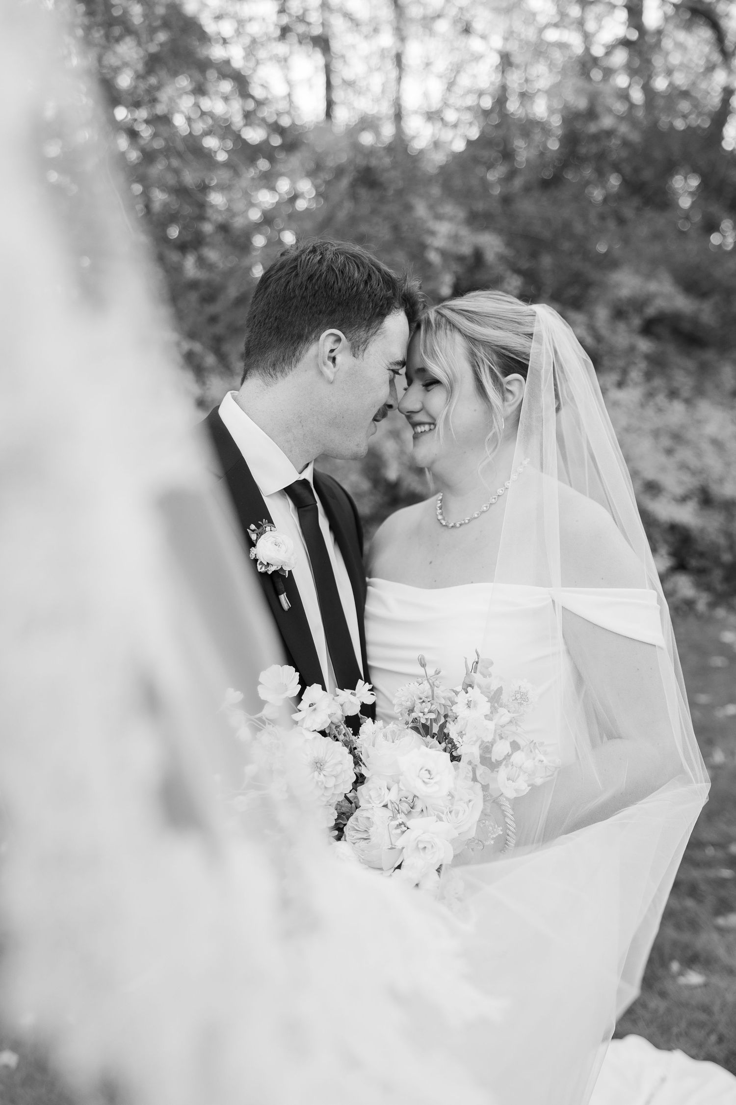 Artistic black and white wedding portraits through delicate veil details.