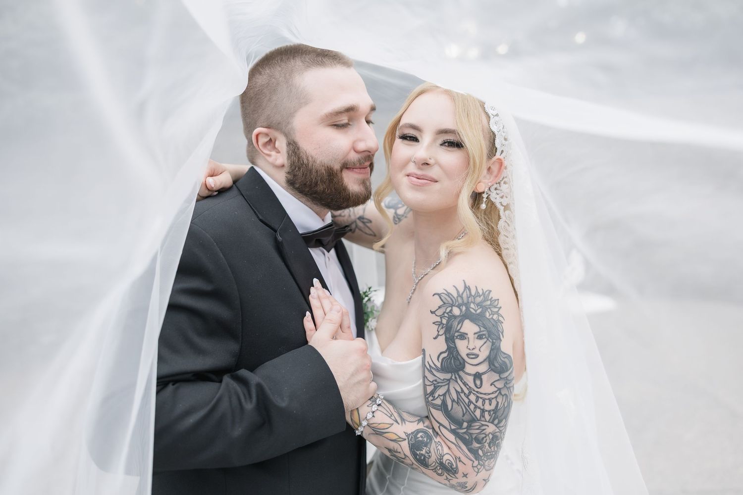 Ethereal winter wedding portraits with soft white lighting and flowing veil.