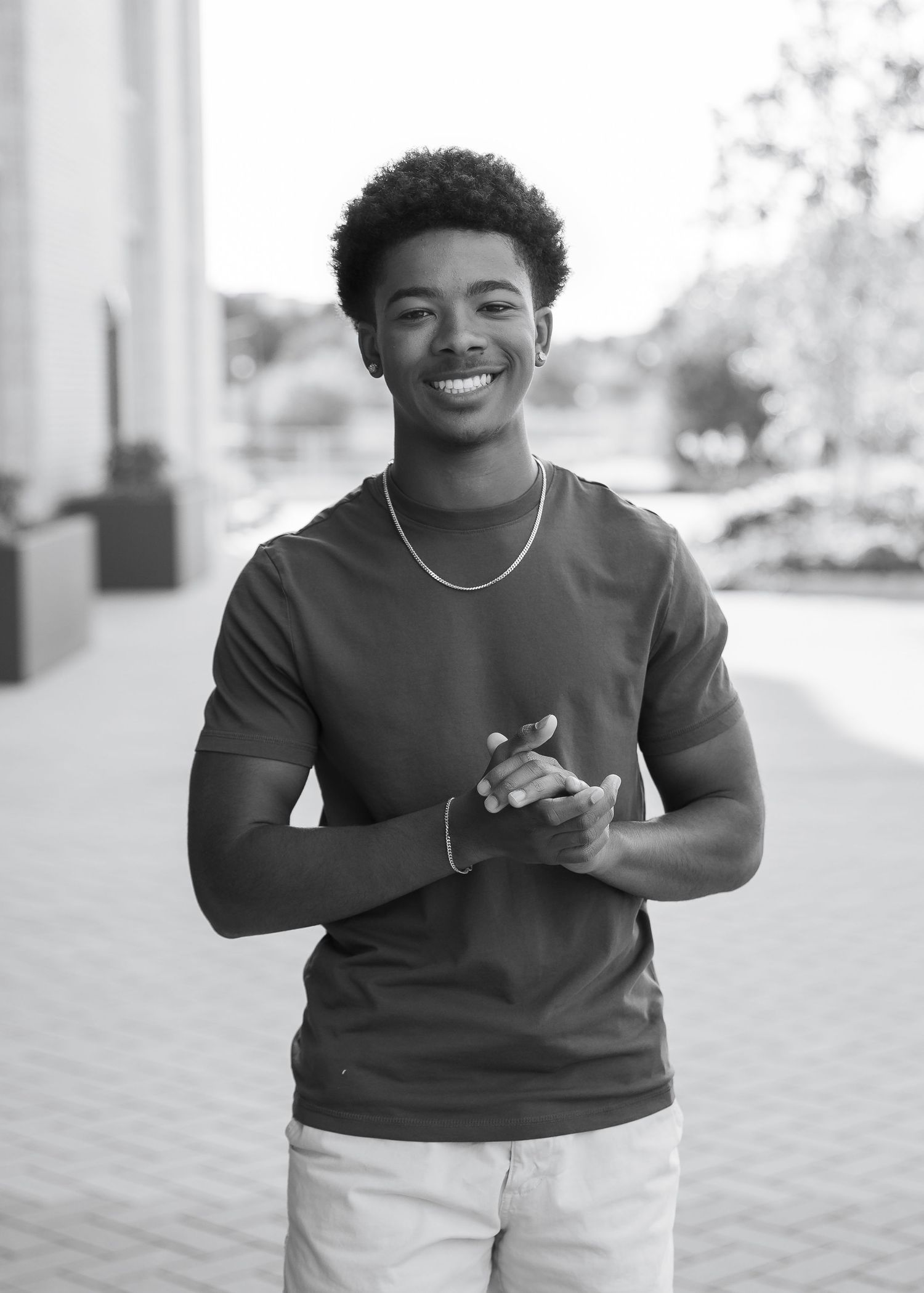 A series of candid black and white photos showing a person in a dark sweater smiling and gesturing expressively.