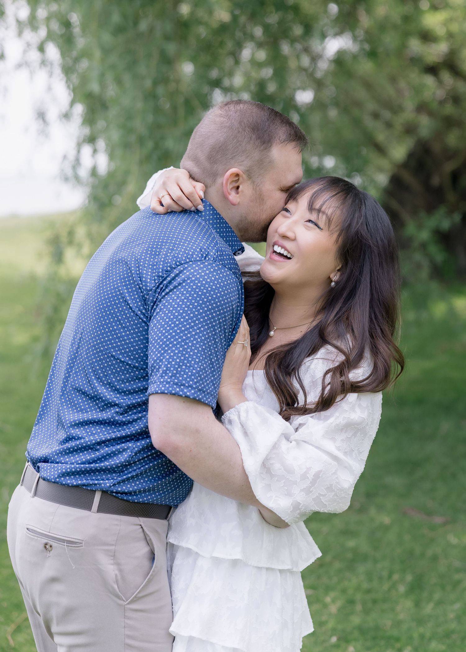 A romantic couple embraces while sharing tender moments in a natural outdoor setting.