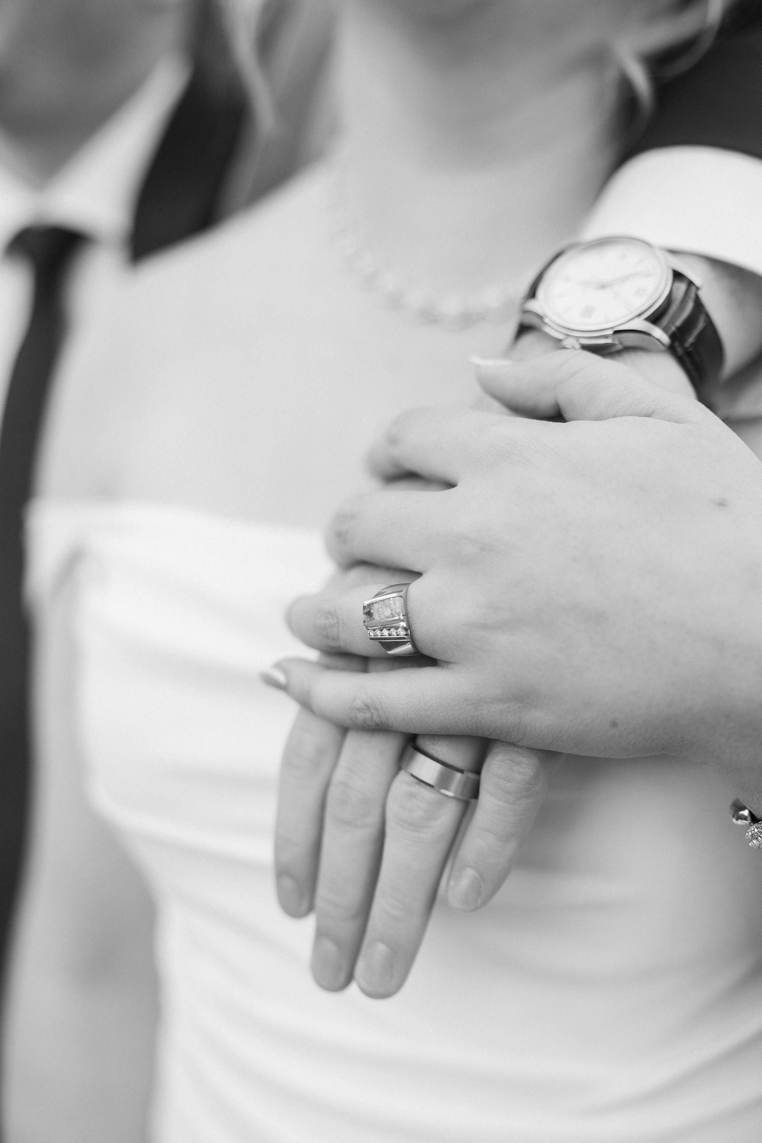 A close-up sequence of hands showing wedding rings in black and white photography.