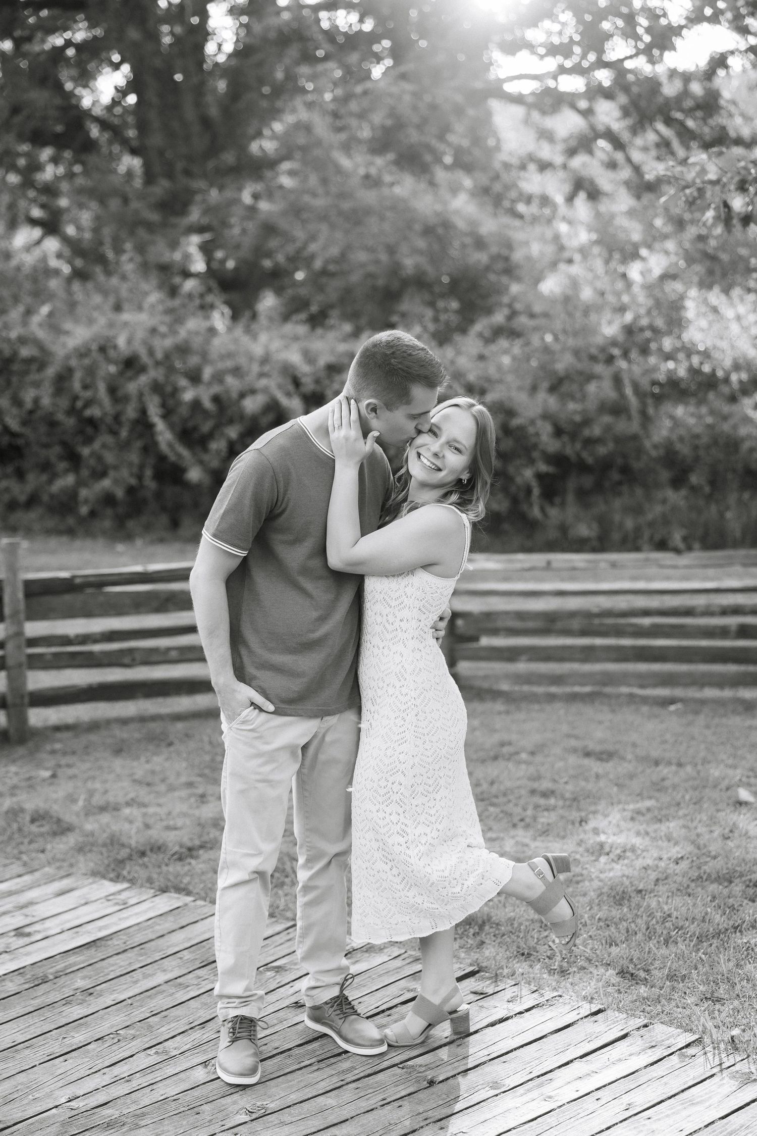 Black and white sequence of a couple walking playfully along a wooden boardwalk in a park setting.