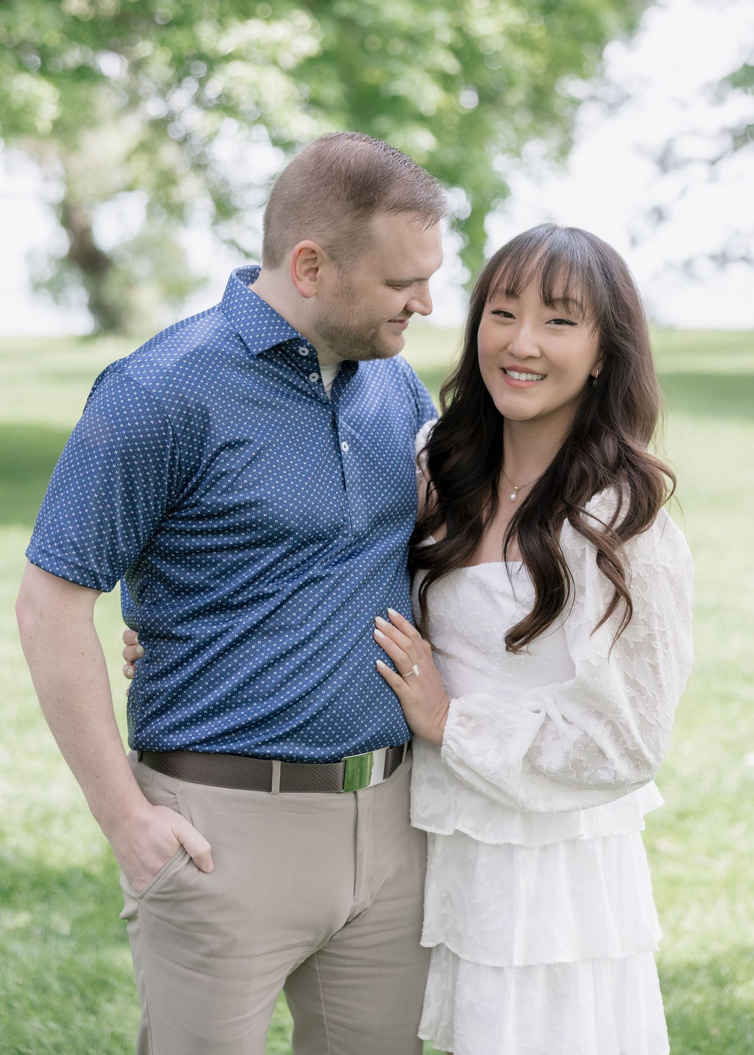 A joyful couple shares intimate moments while walking together in a garden setting.