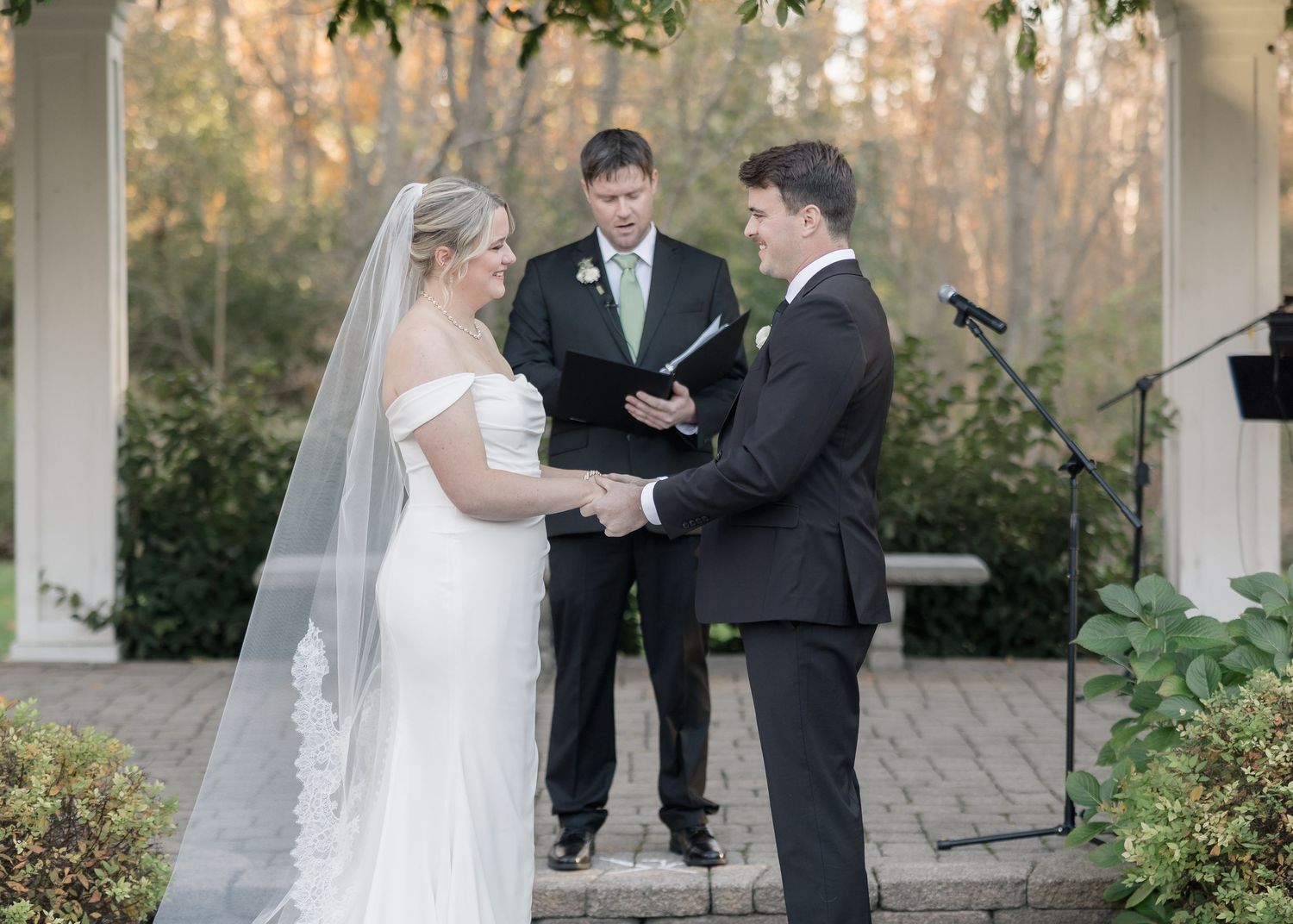Intimate wedding ceremony moment captured under an ivy-covered pergola.
