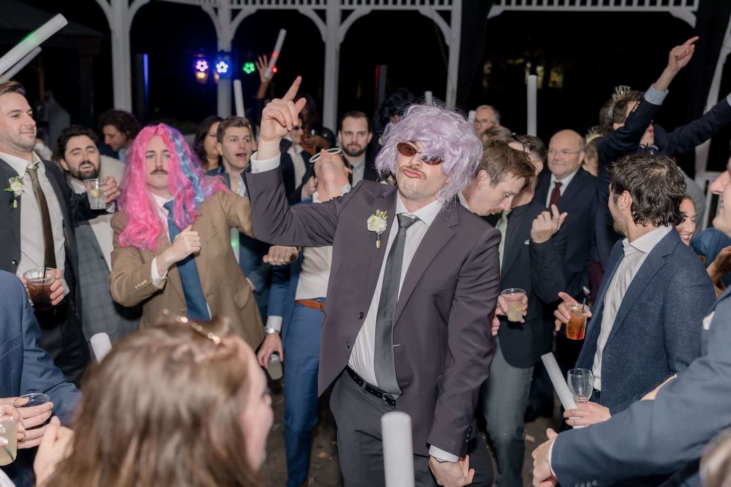 Wedding reception dance party with guests in costumes and props.