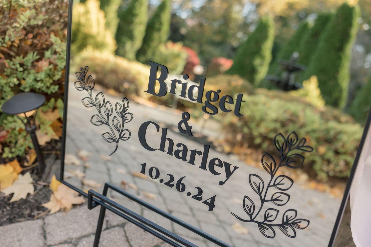 Clear acrylic wedding sign with elegant floral designs and wedding date details.