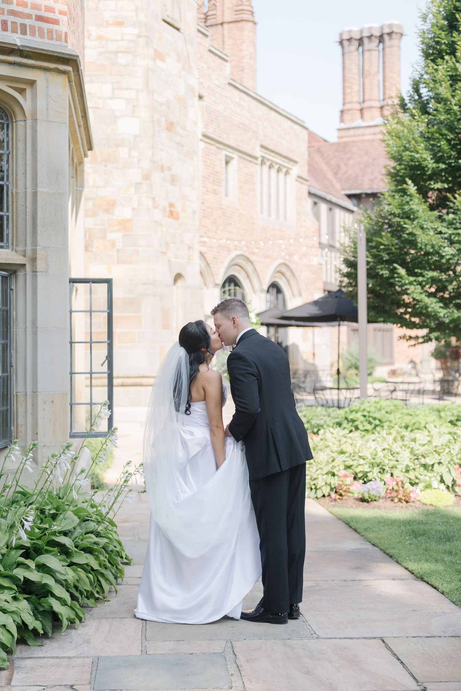 Romantic wedding portraits taken outside a historic brick church building.
