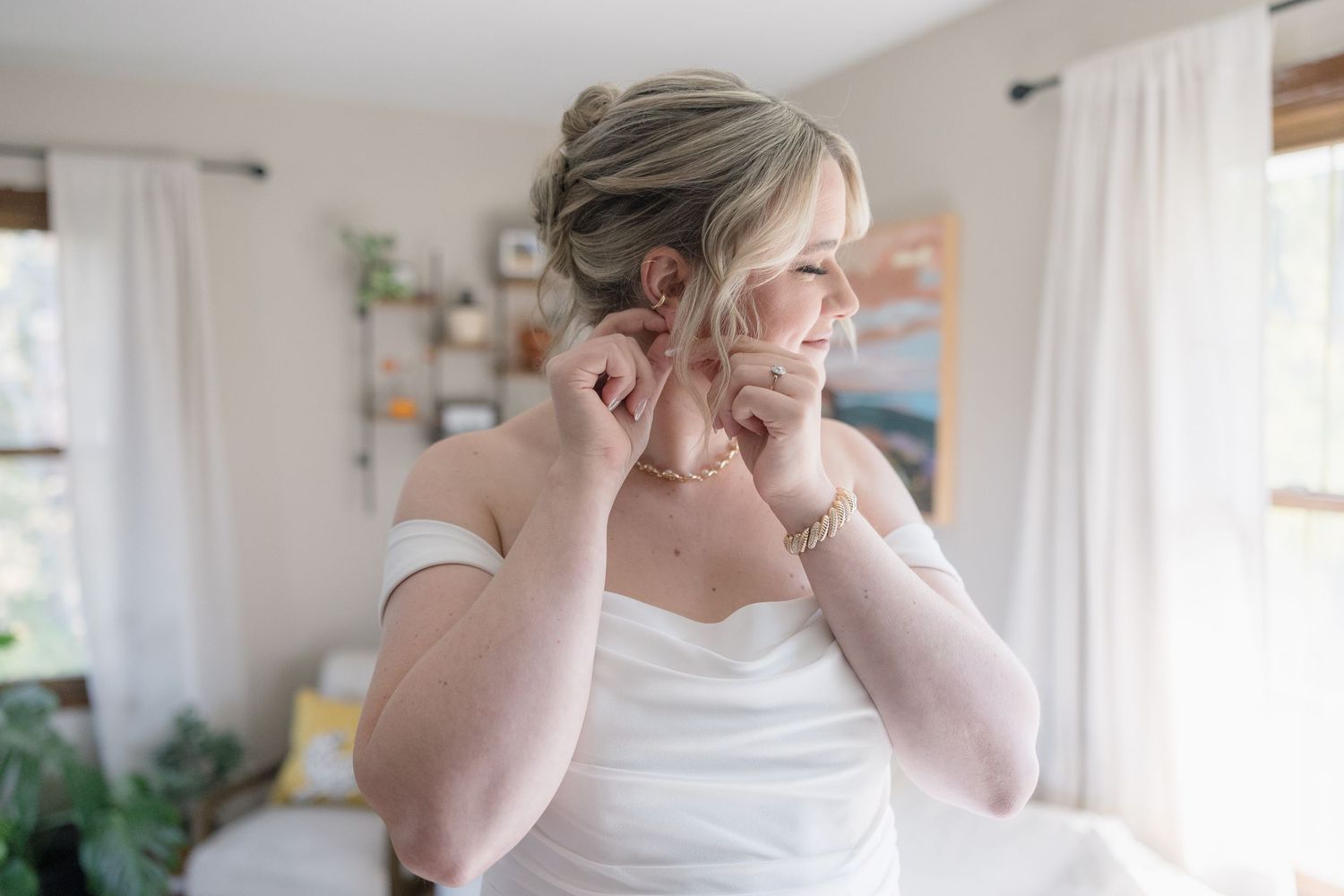 A classic bridal preparation moment showing jewelry and dress details.