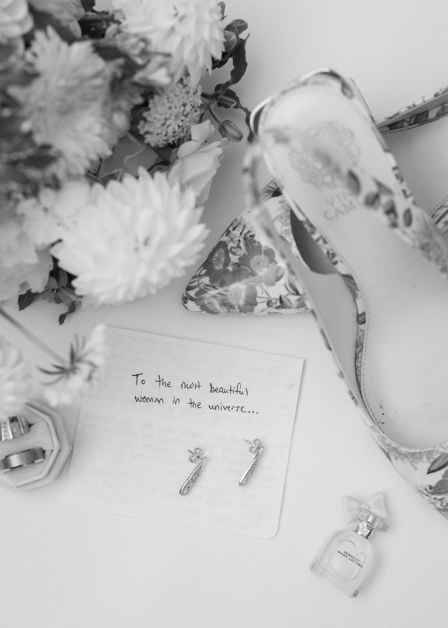 Artistic black and white detail shot of wedding notes and flowers.