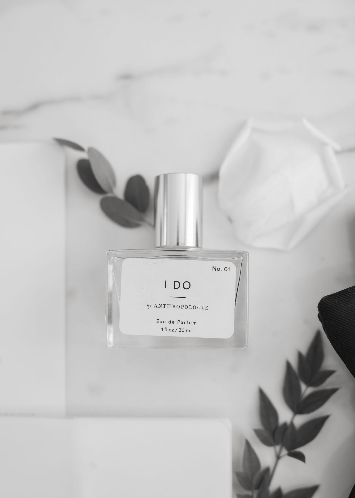 Anthropologie I Do No.01 Eau de Parfum bottle on marble surface with eucalyptus leaves.