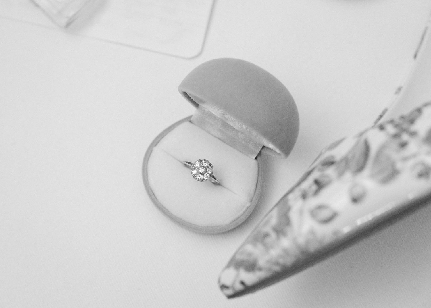 An elegant engagement ring with a solitaire diamond displayed in a grey ring box.