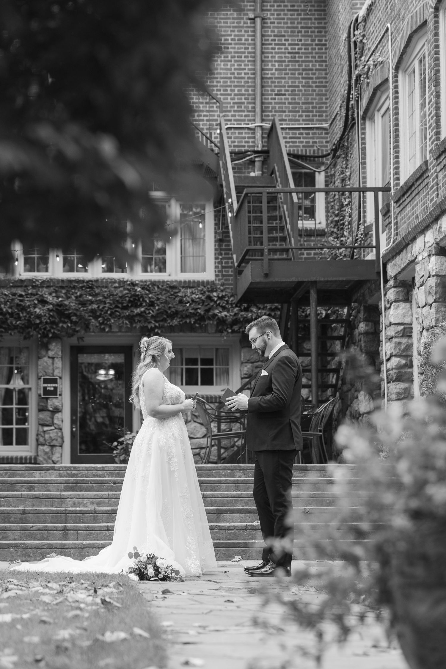 A series of four black and white wedding photos showing a couple in front of a brick building exterior.