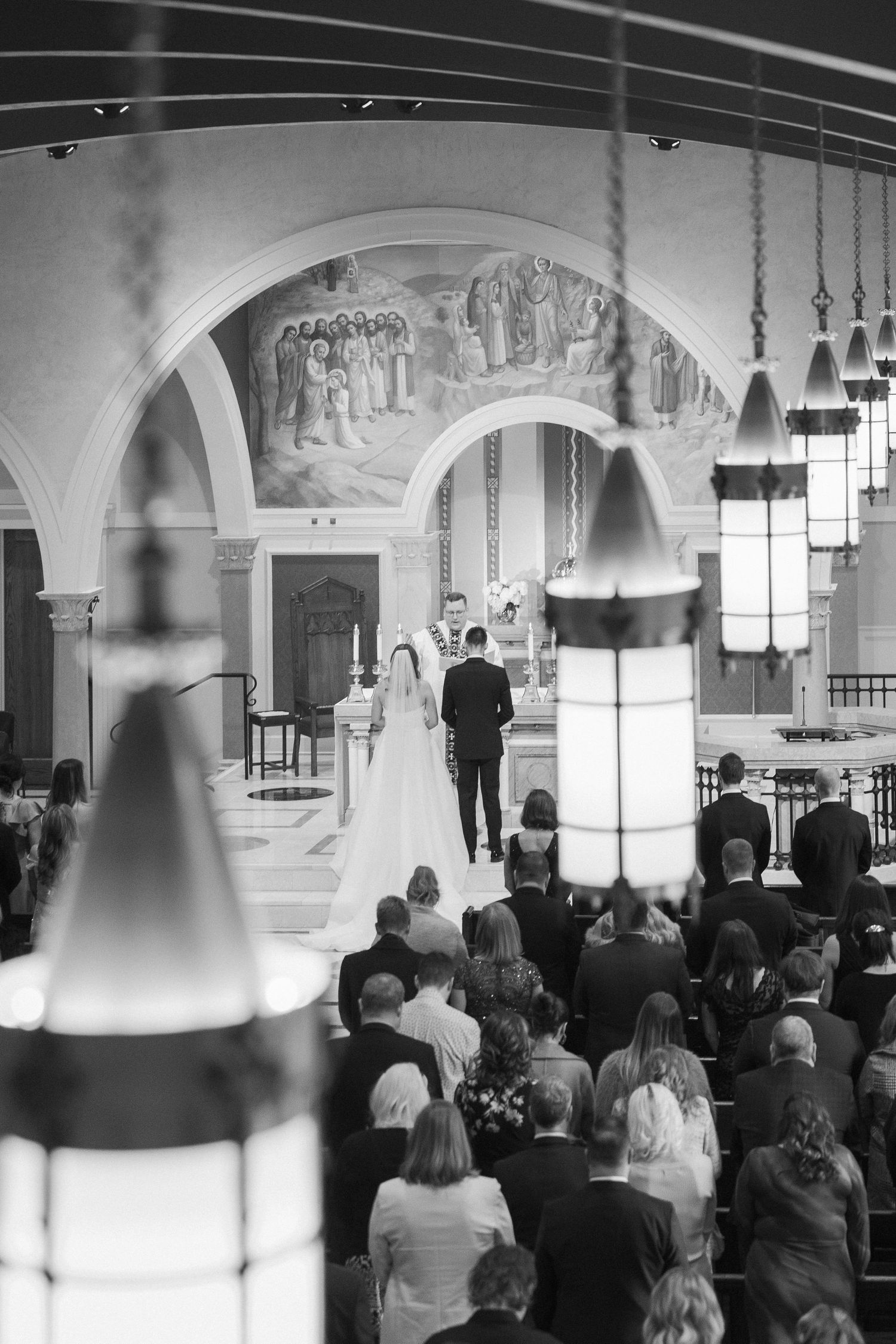 Black and white wedding ceremony photos inside historic church with arched architecture.