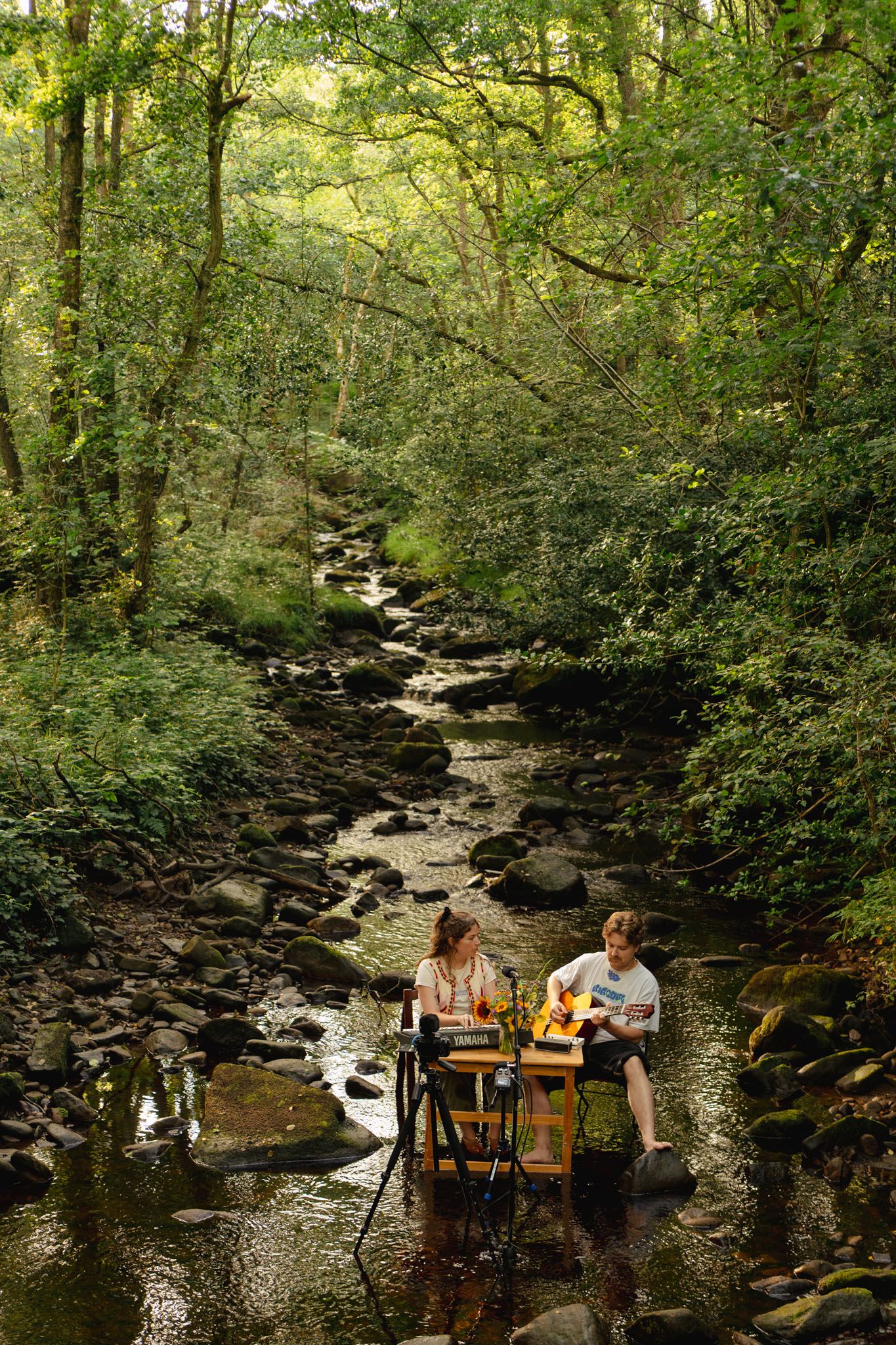 Two musicians playing sat in a river