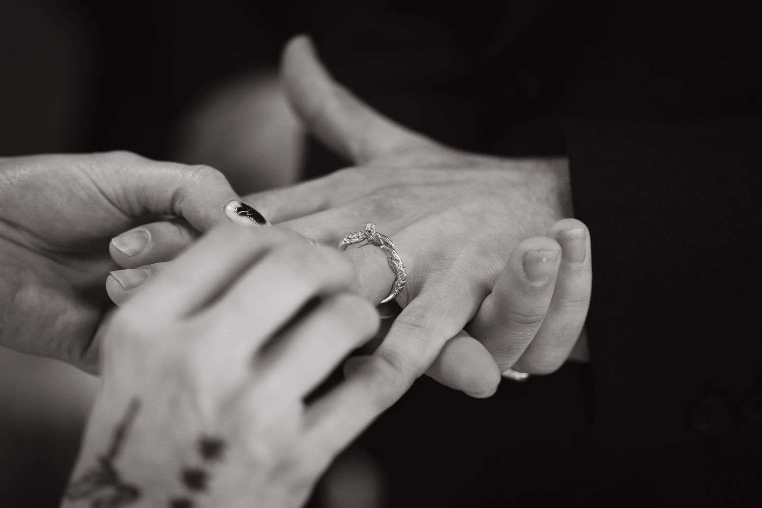 Bride puts ring on grooms finger
