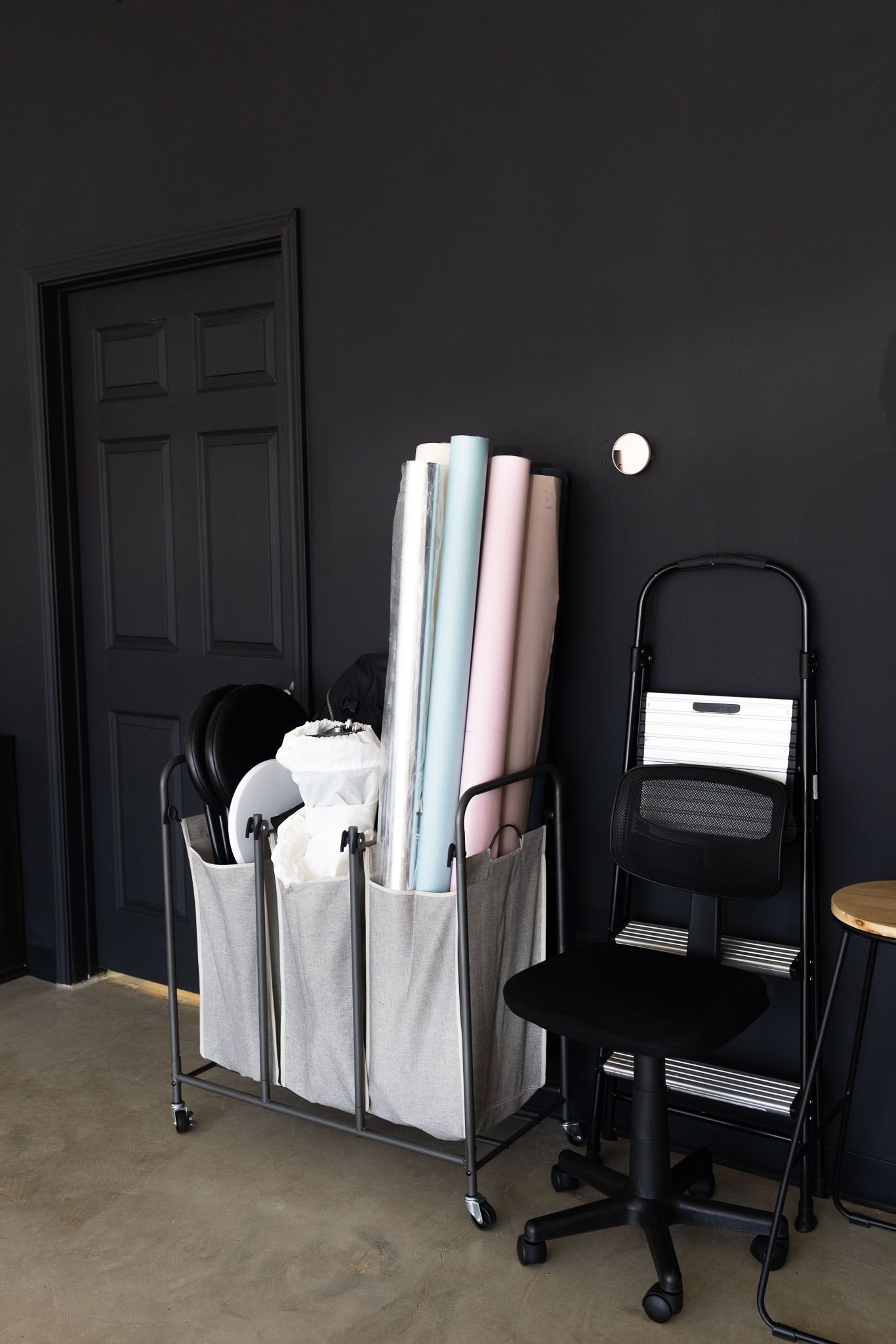 A sequence of photos showing a rolling cart with white storage bins against a dark wall in varying lighting conditions.