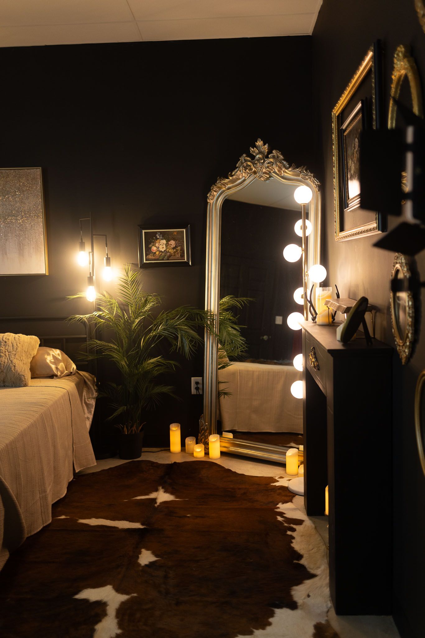 Dark moody spa room with massage table, ornate mirror, and ambient lighting creating a luxurious atmosphere.