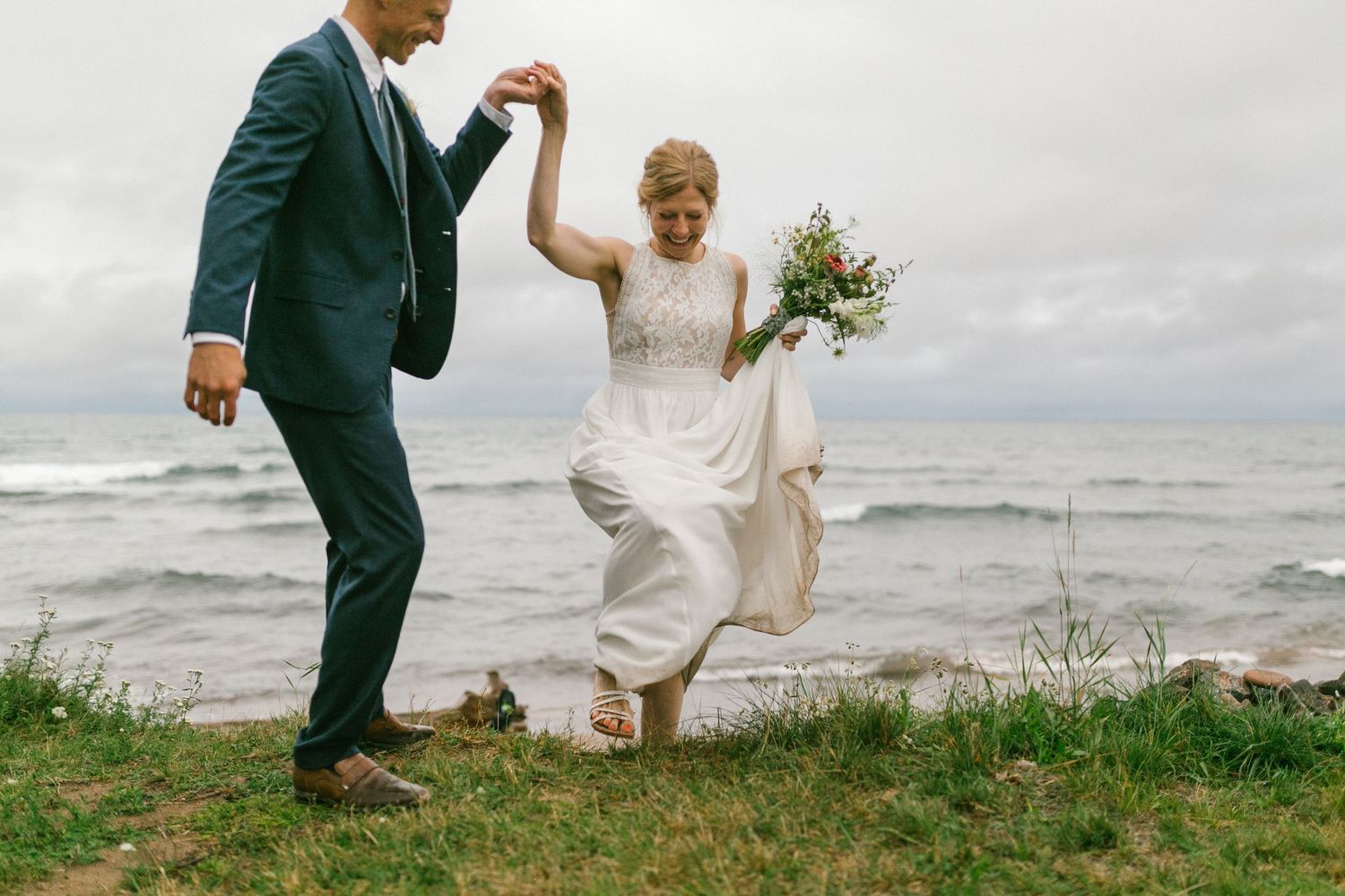 A joyful dance moment on a coastal cliff with waves in the background.