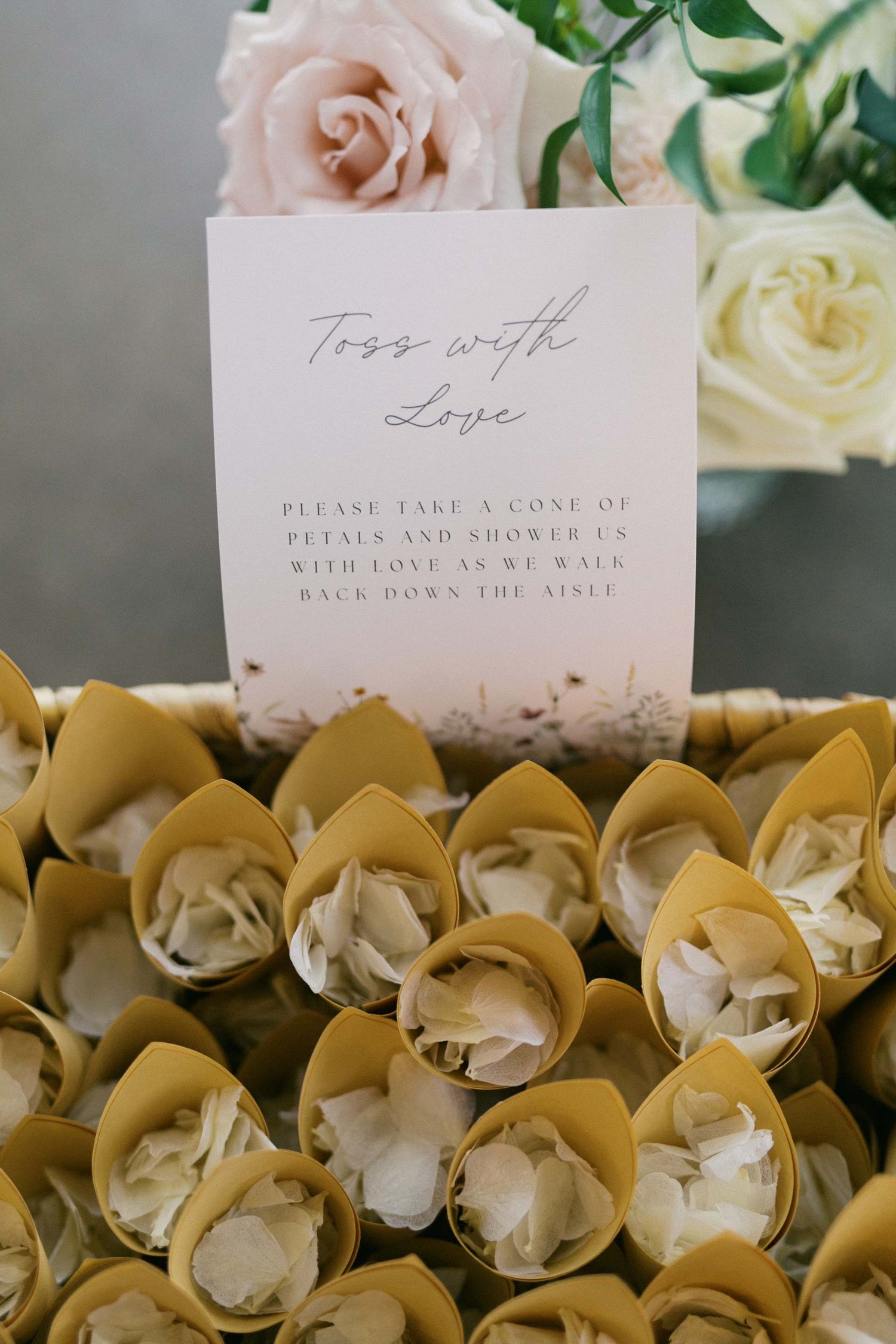 Elegant wedding place cards displayed among delicate yellow and white orchid flowers with handwritten calligraphy.