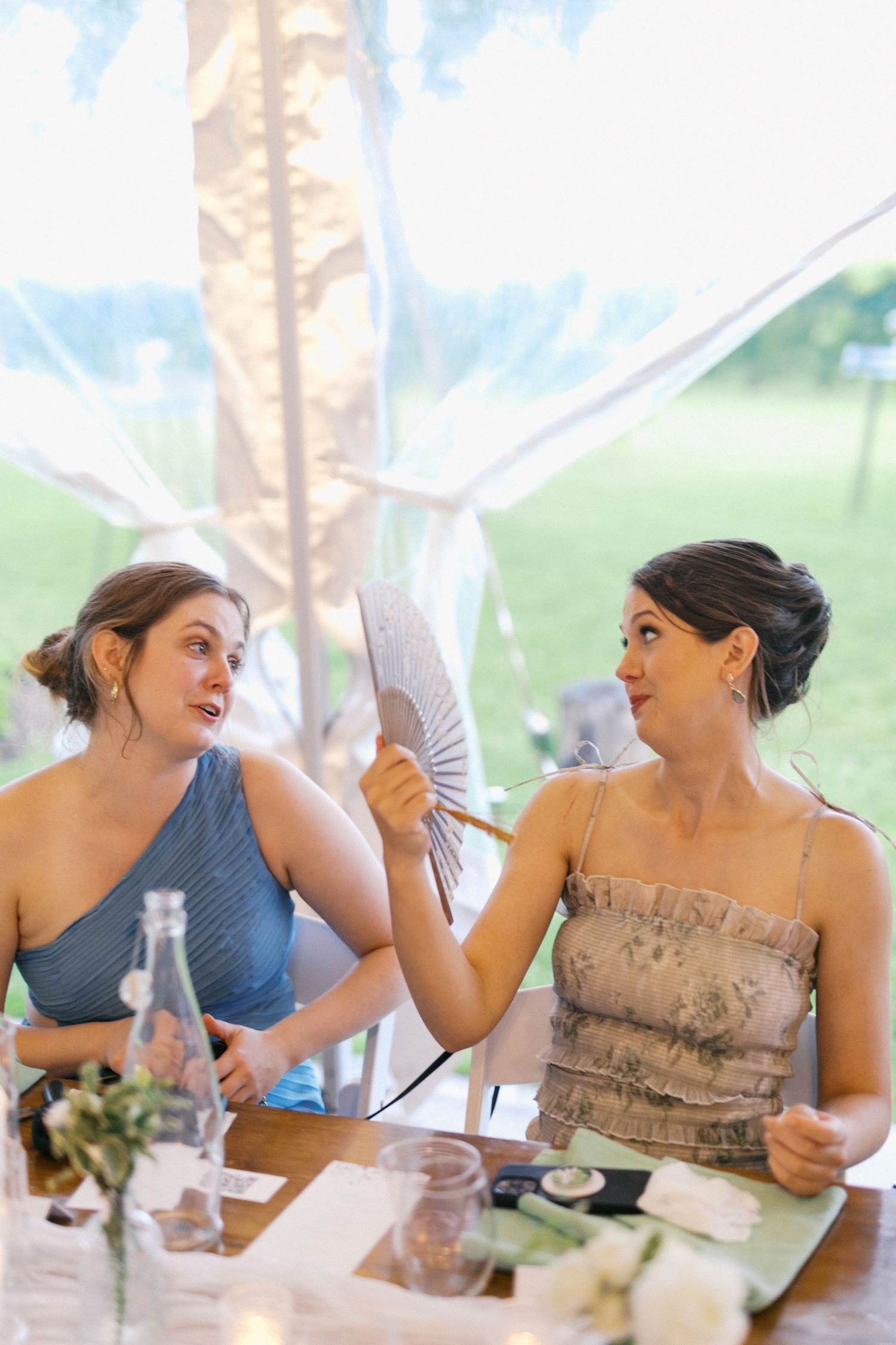 A sequence of candid moments shows someone in a beige dress fanning themselves and reacting expressively at a table.