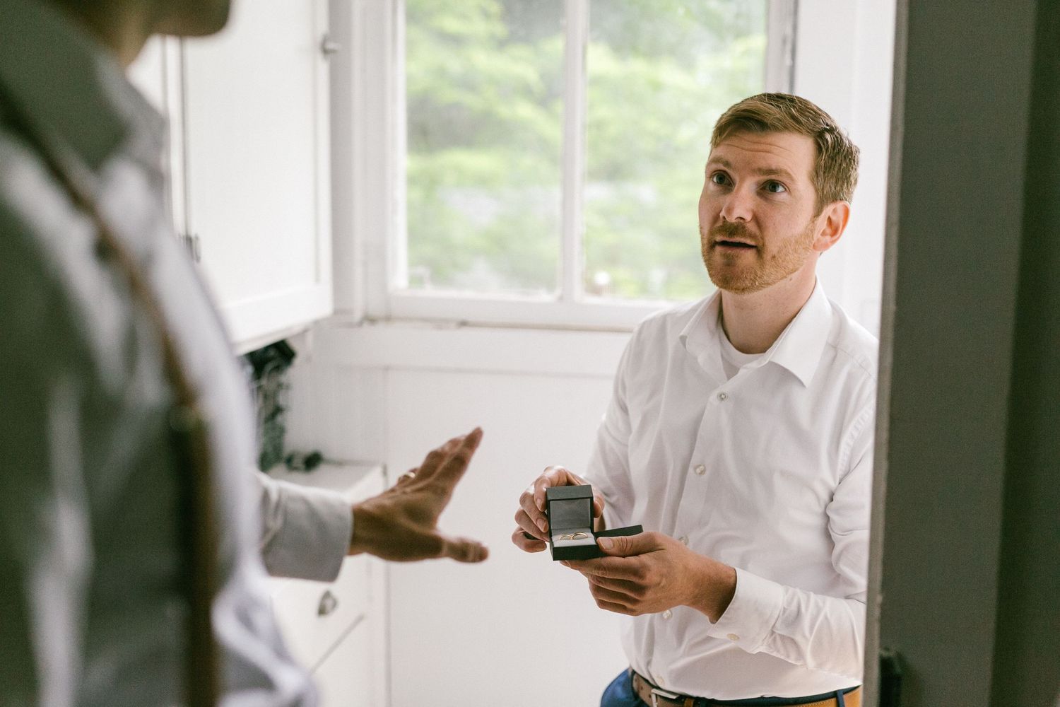 Two people having a business conversation in a bright office space while one holds a phone.