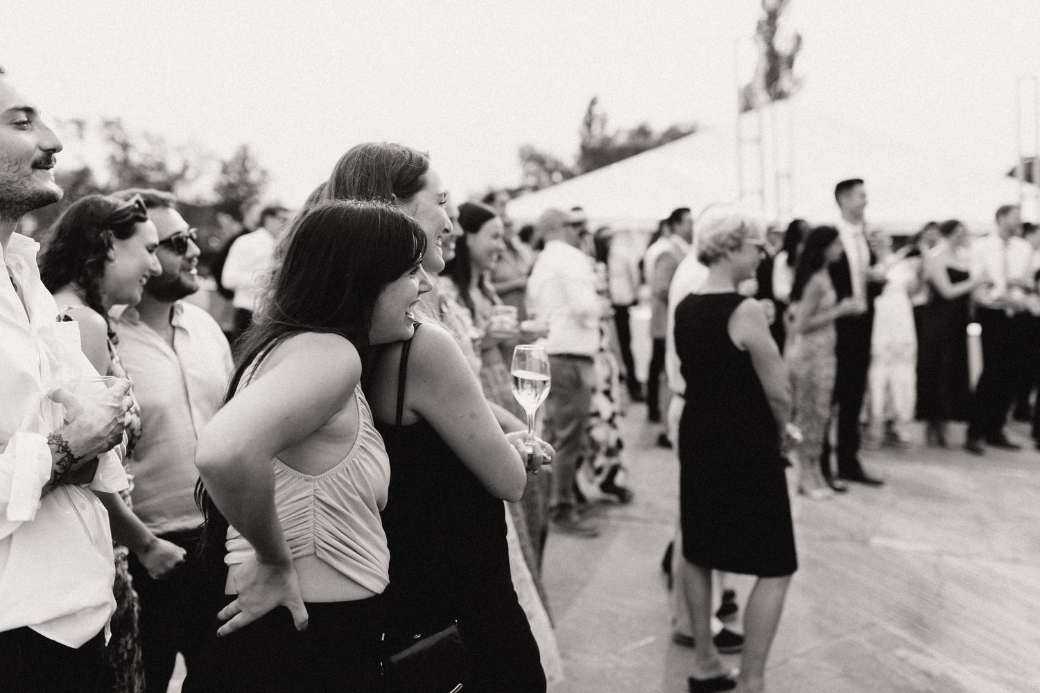 Wedding guests celebrate outdoors during a festive summer reception.