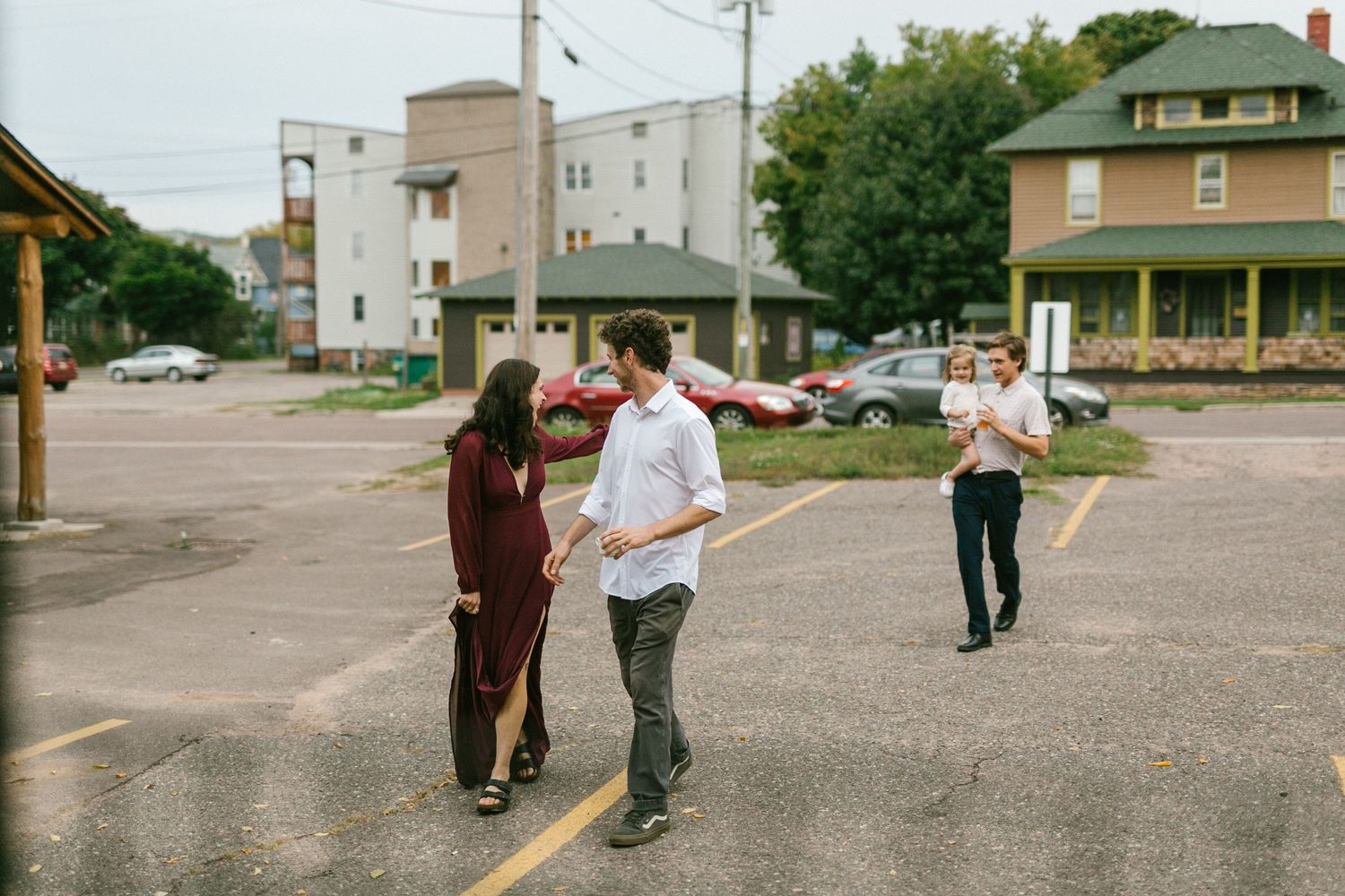People dancing and socializing on a paved street with residential buildings in the background.