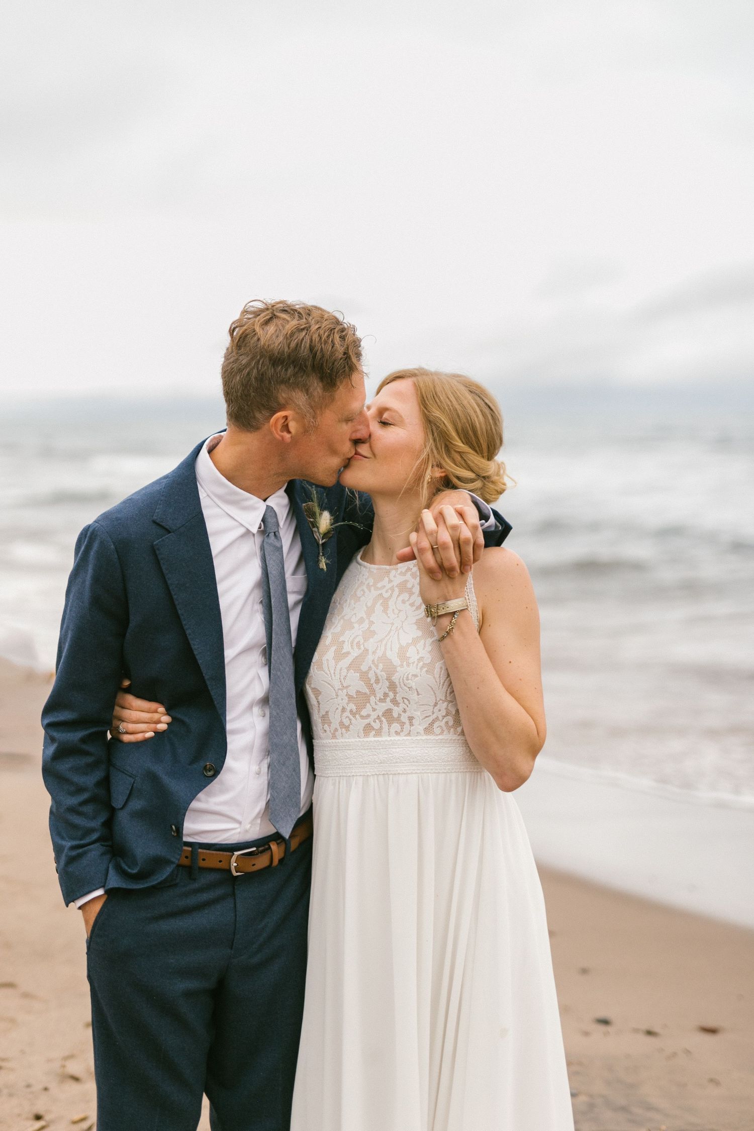 A romantic beachside wedding portrait with soft natural lighting and ocean waves.