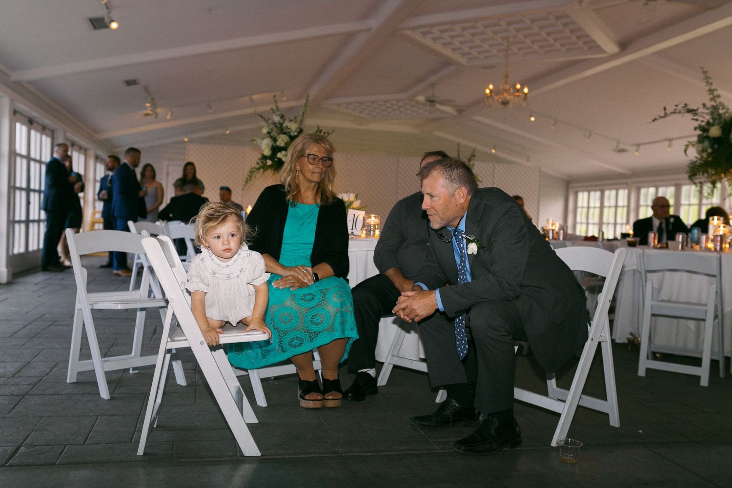 Wedding reception venue with white chairs and tables set up in a bright, modern space.