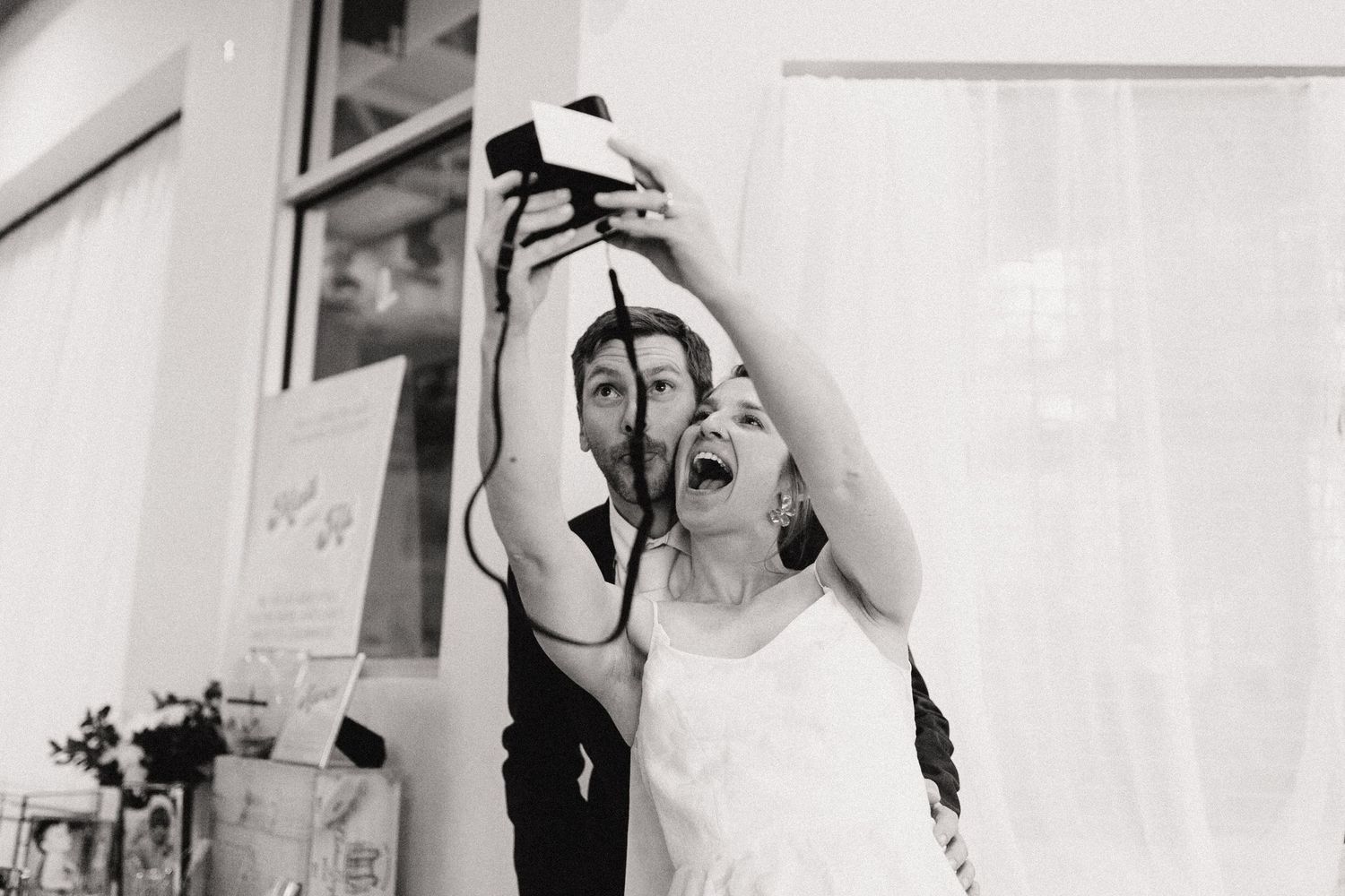 Someone pours champagne into their mouth while celebrating in a black and white photograph.