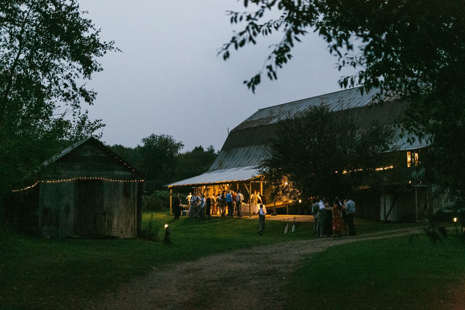 A series of panoramic photos showing a rustic barn with glowing lights at dusk across different angles and lighting conditions.