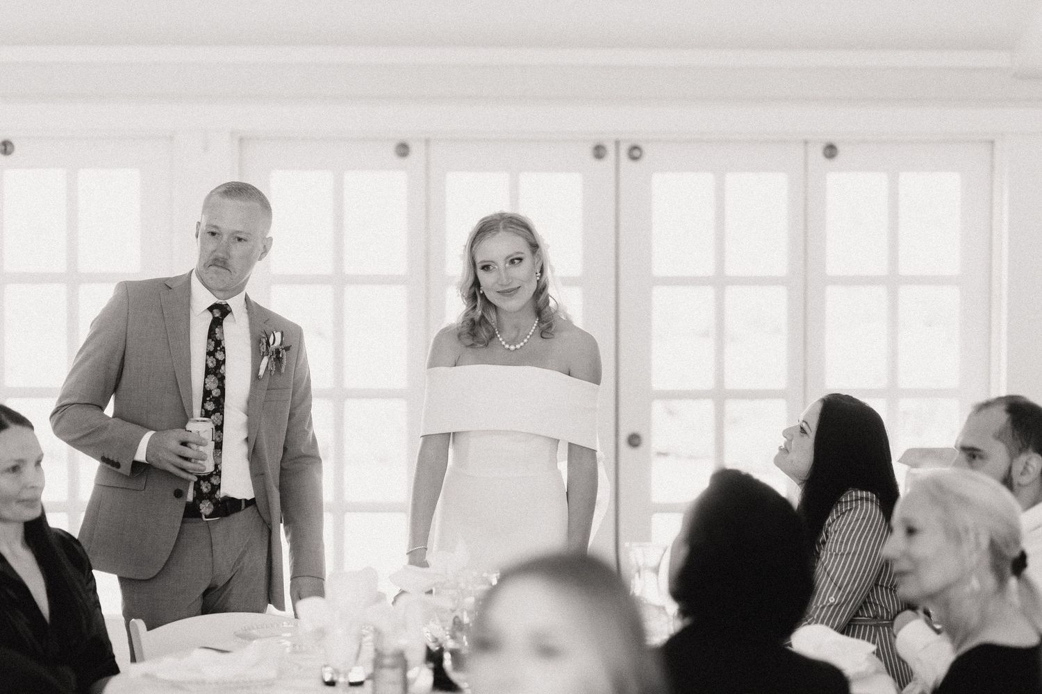 A wedding couple shares their first dance together on a white marble floor at an elegant reception venue.