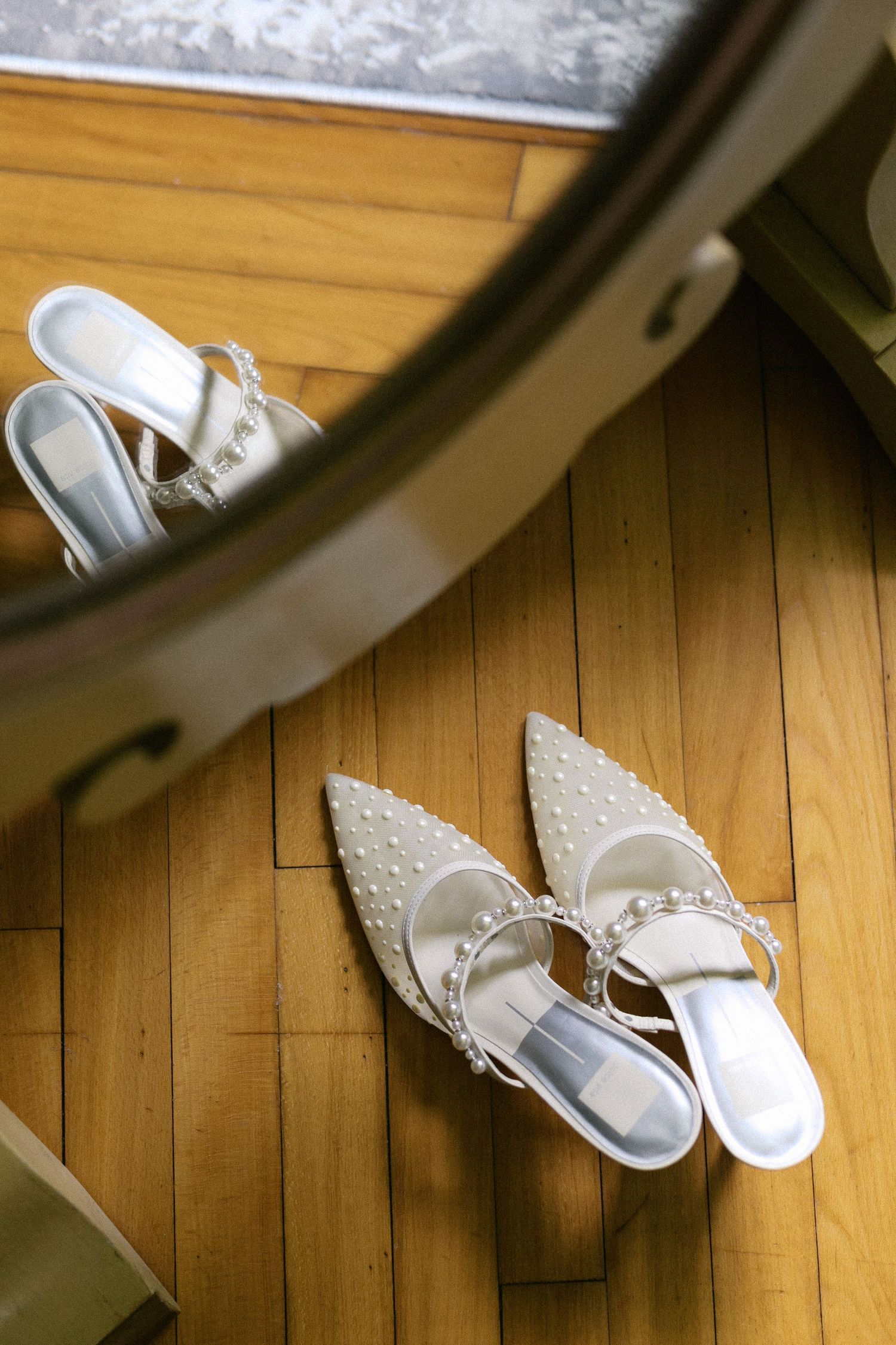 White bridal shoes arranged on a hardwood floor in varying compositions.