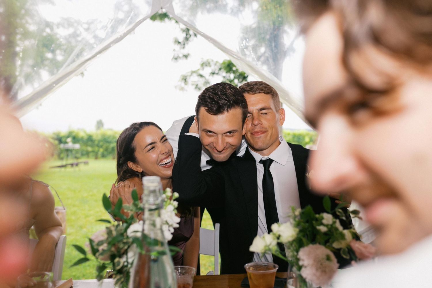 A couple shares an intimate moment during their wedding celebration in an outdoor garden setting.