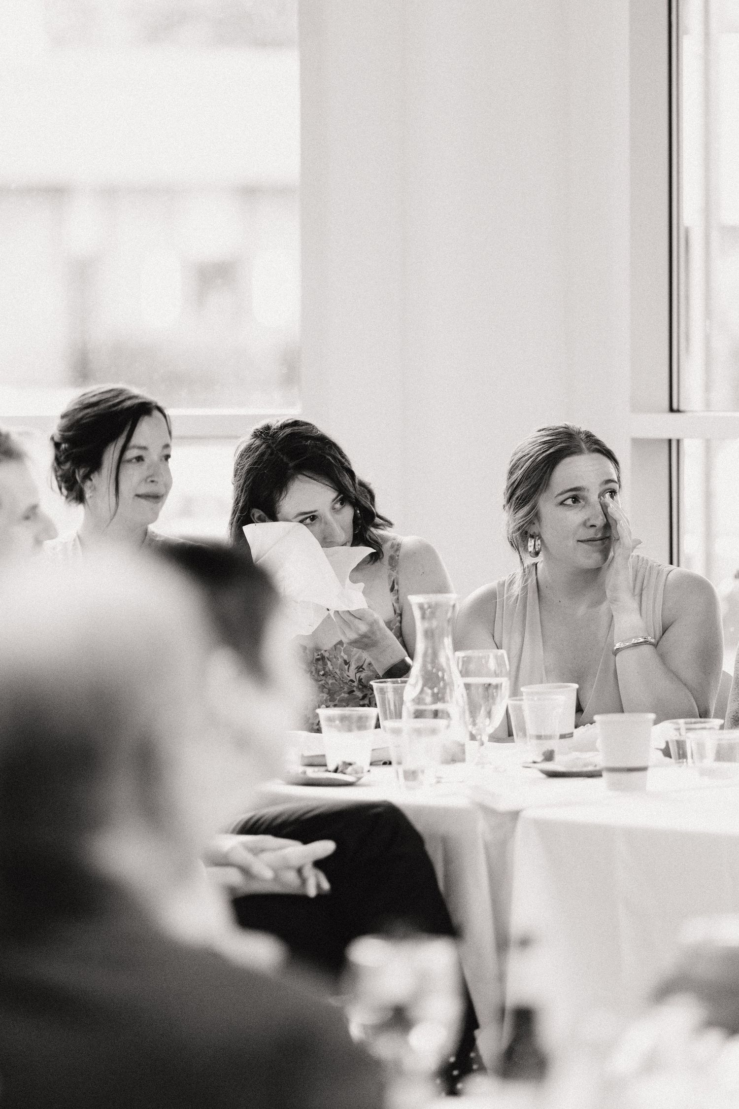 Black and white photo of guests seated at a reception table during an elegant event.