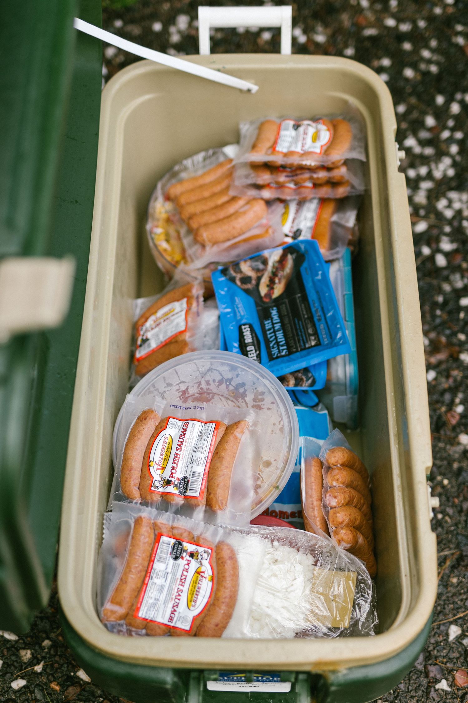 A cooler filled with packaged sandwiches and drinks for a chill wedding reception.