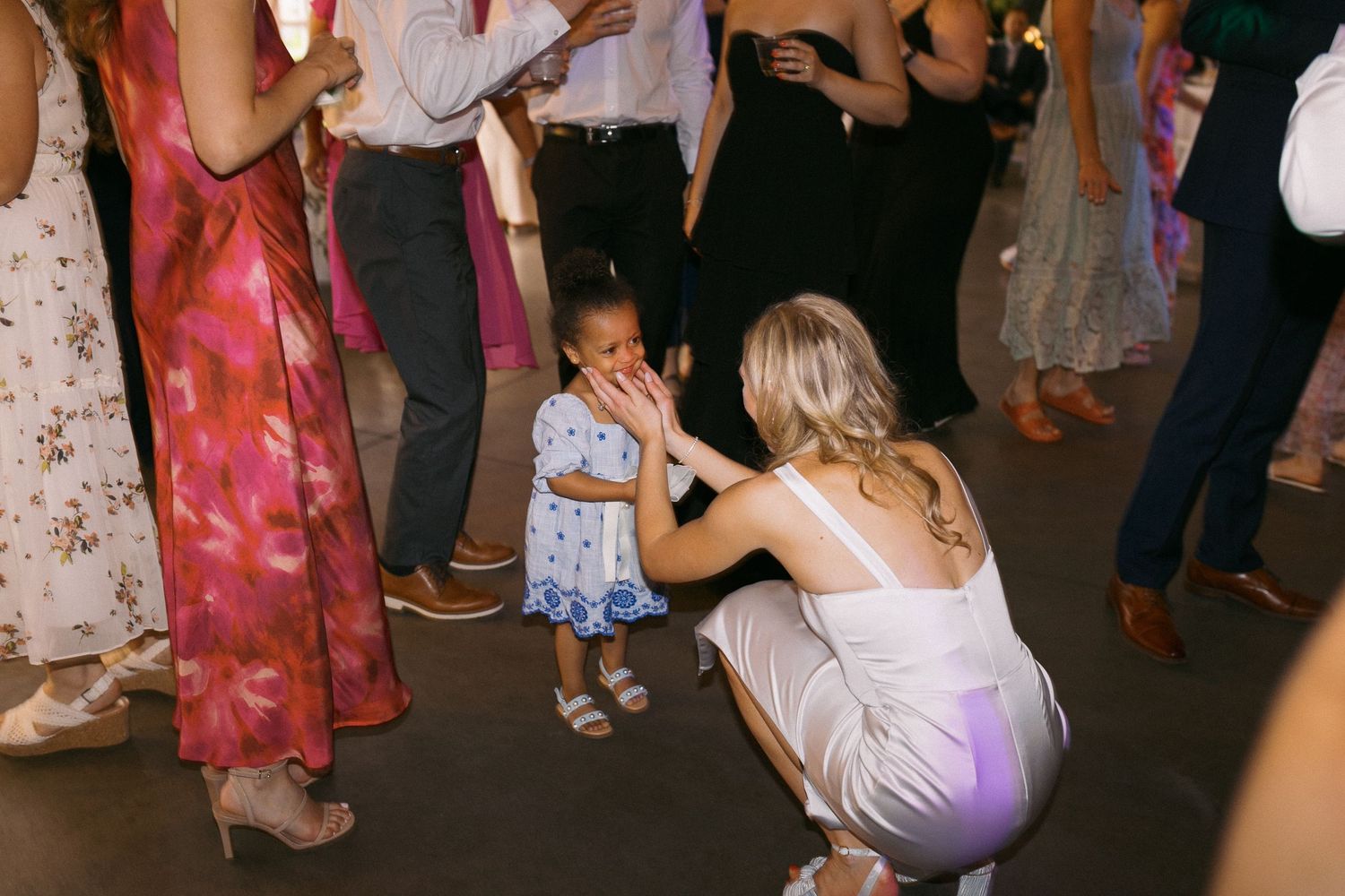 Wedding reception dance floor filled with guests in colorful attire enjoying the festivities.