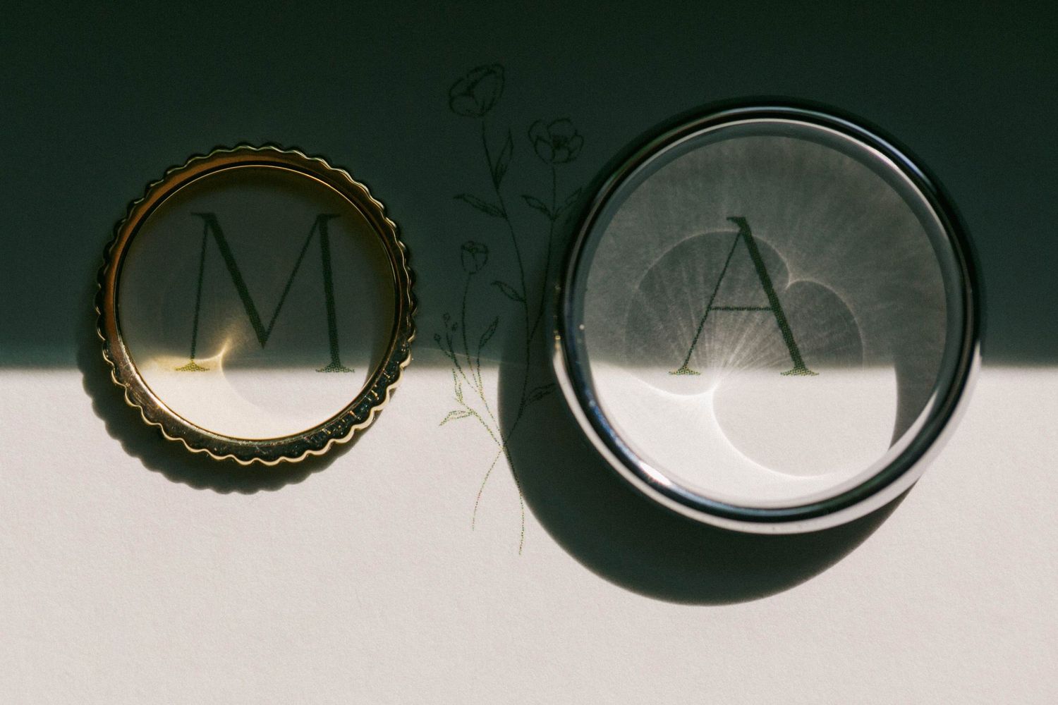 Two wedding rings elegantly placed above the first initial's of the bride and groom.