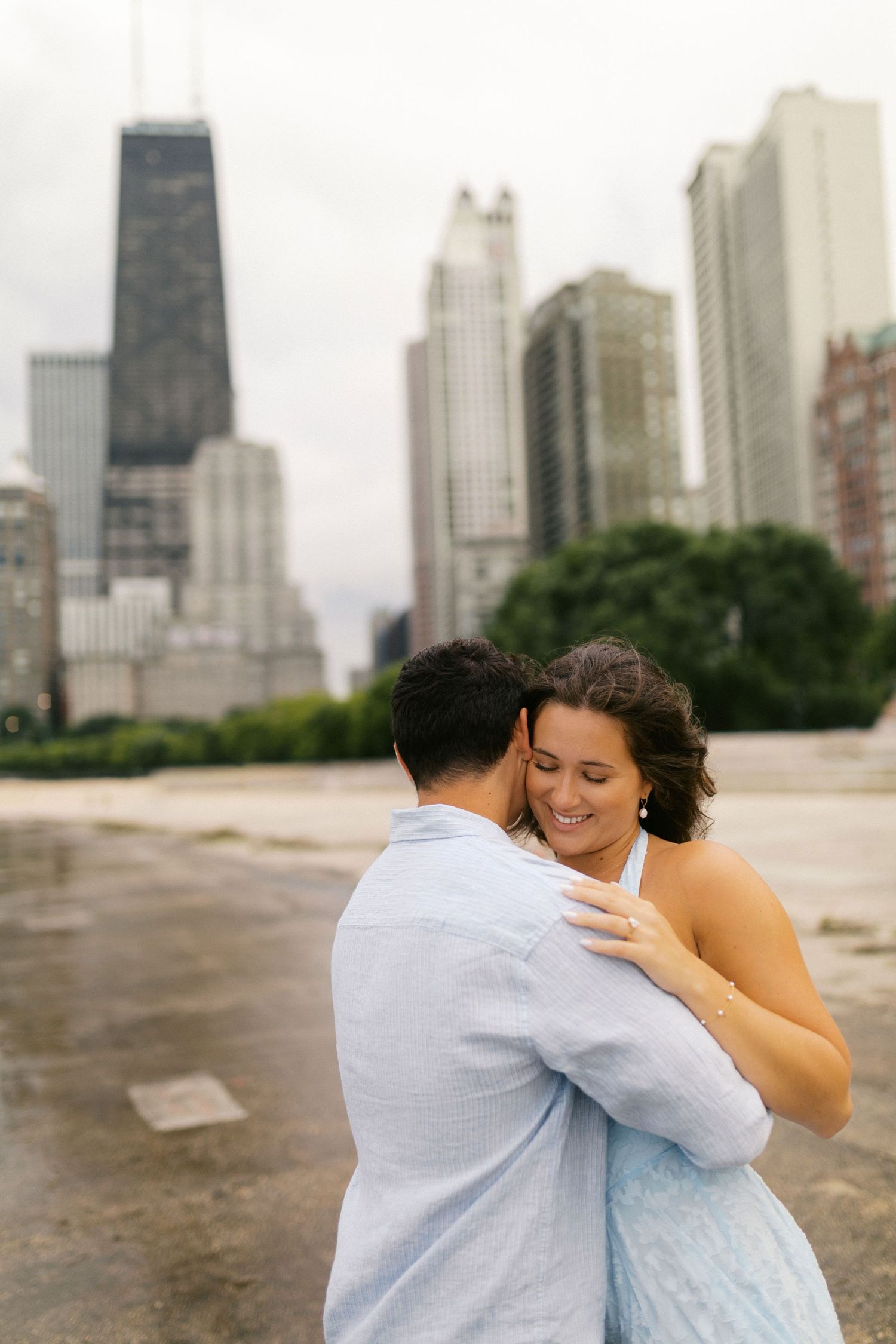 Couple dancing and embracing with the Chicago skyline and John Hancock Tower in the background.
