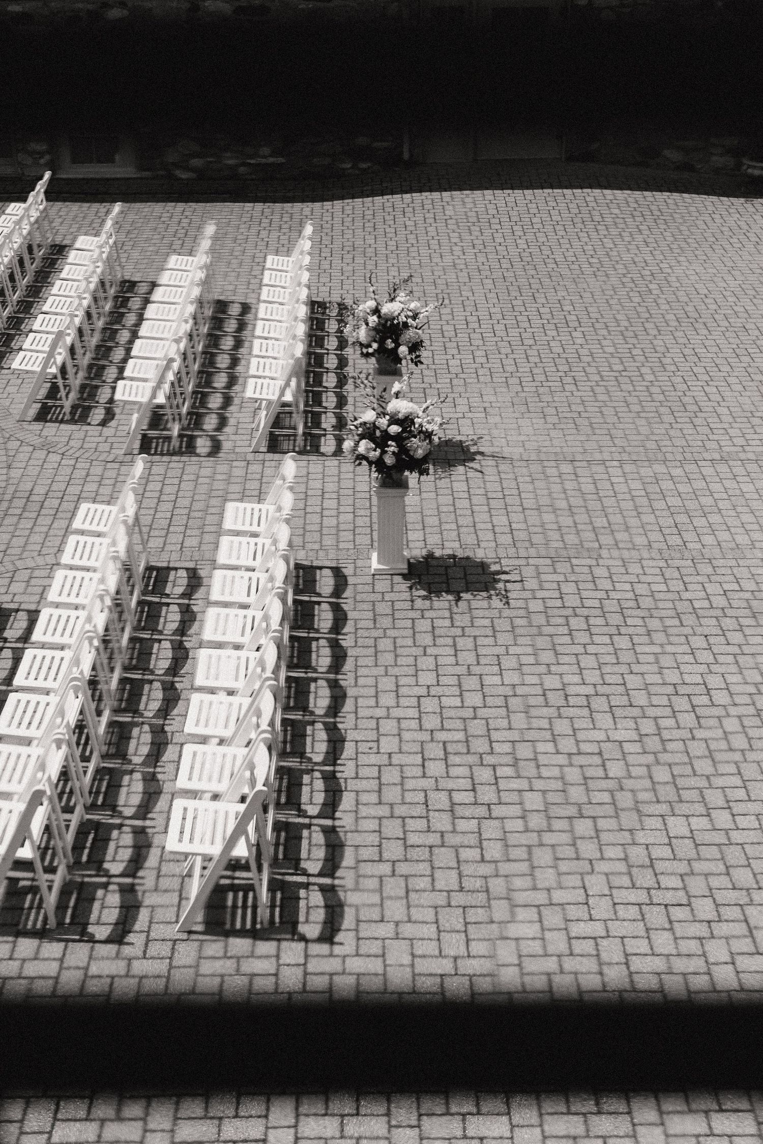 Sequence of black and white images showing progressive movement of chairs and objects on a patterned brick patio.