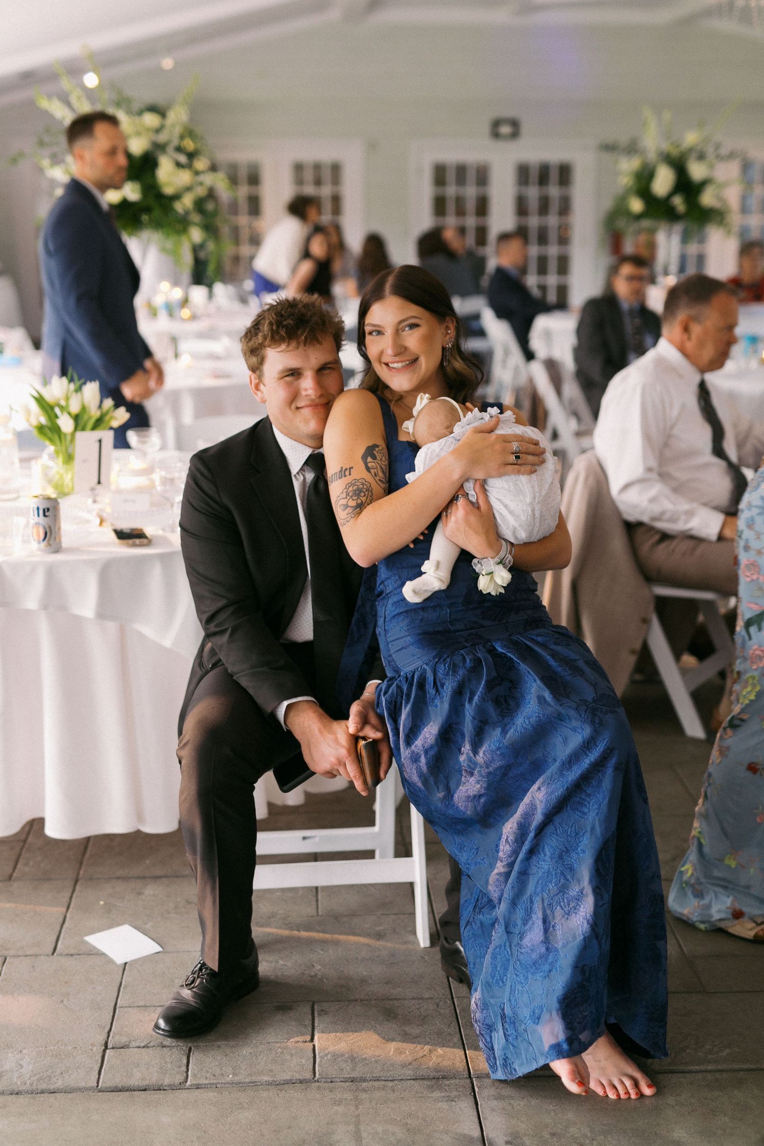 Wedding reception guests in formal attire sharing playful moments on the dance floor.