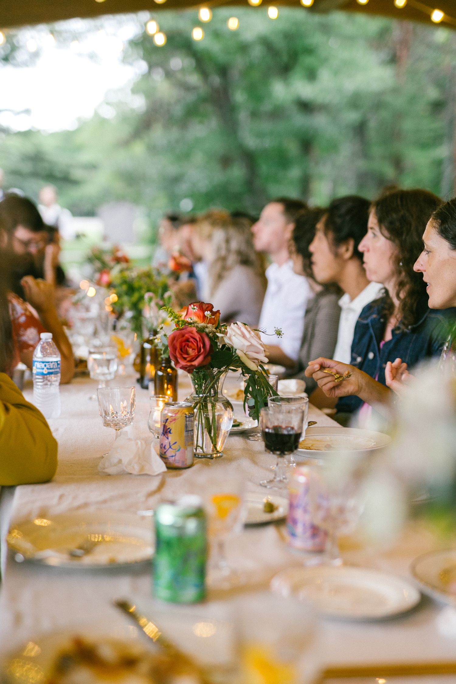 Elegant table settings with floral centerpieces and glowing candlelight at a reception dinner.