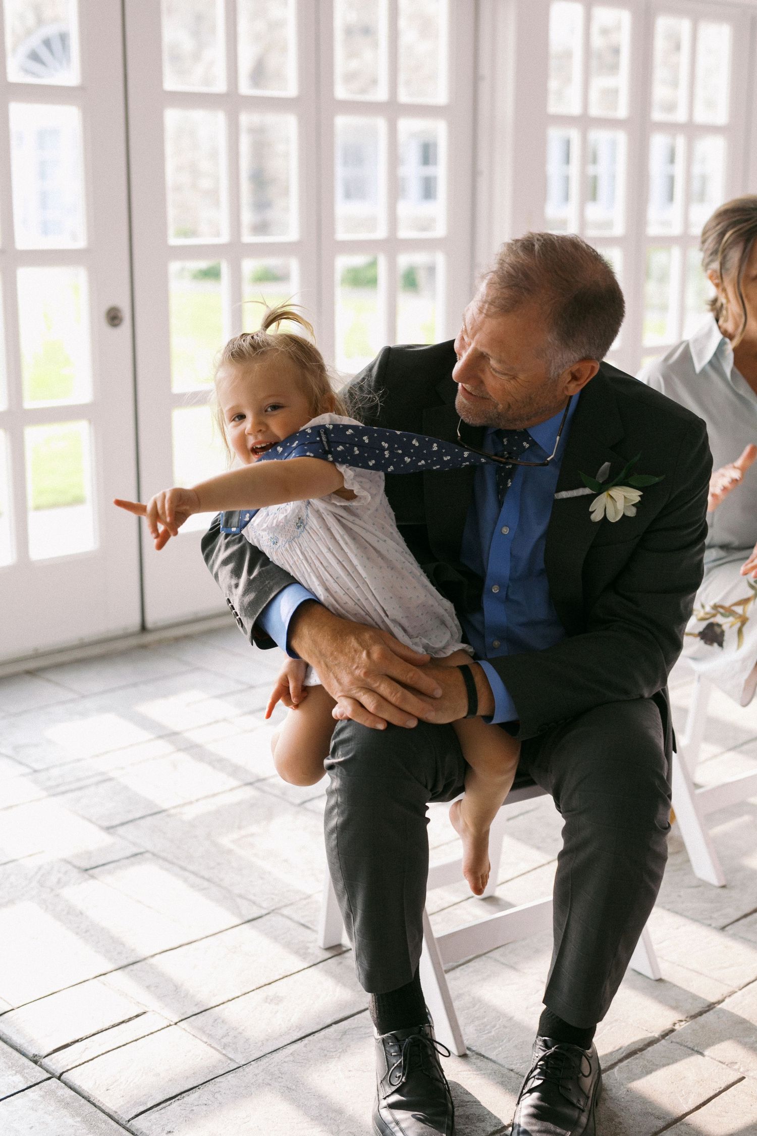 Playful dance move being performed in a bright sunlit room with white walls and windows.