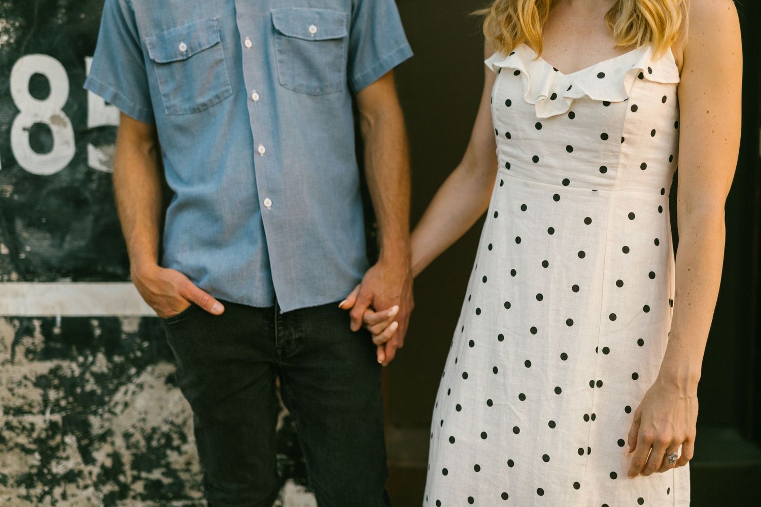 Close-up of hands holding against a dark textured wall with vintage numbers.
