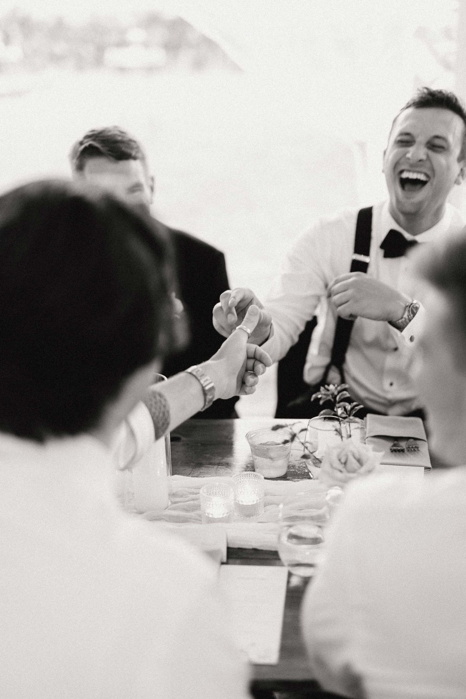 Black and white sequence of candid moments showing laughter and joy during a dinner reception celebration.
