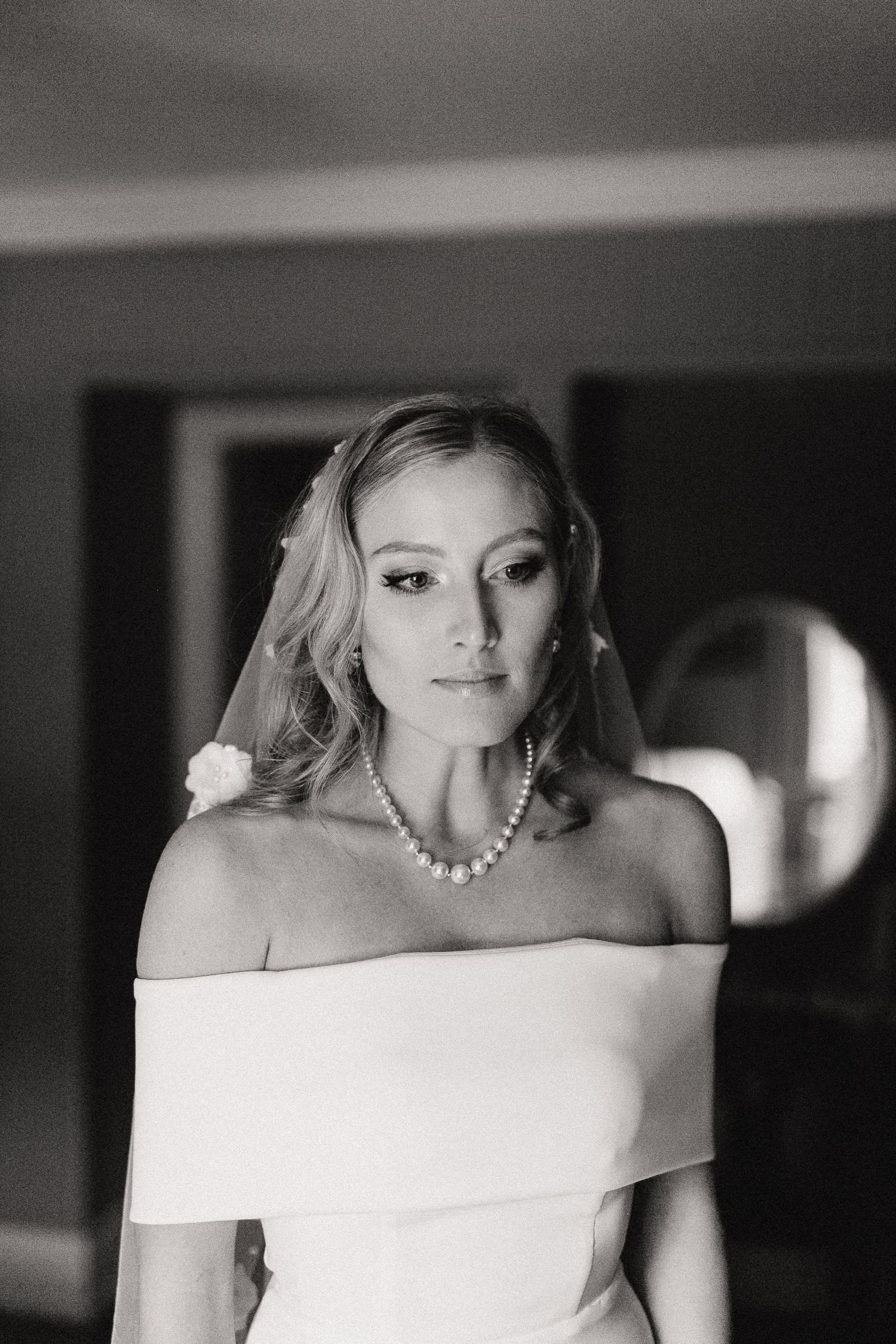 Artistic black and white bridal portrait featuring an elegant off-shoulder wedding dress.