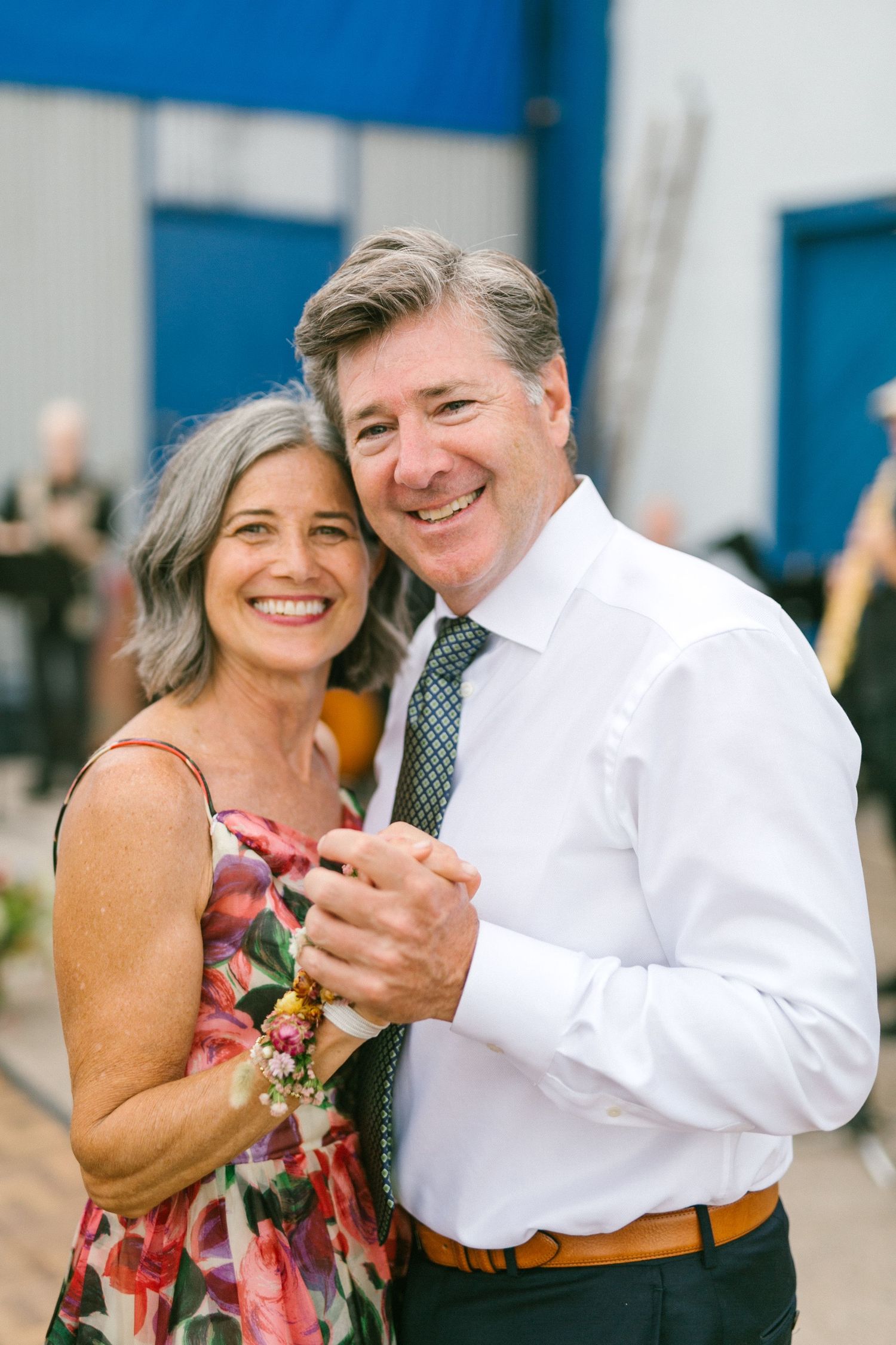 Couple dancing together at an outdoor event with joyful expressions.